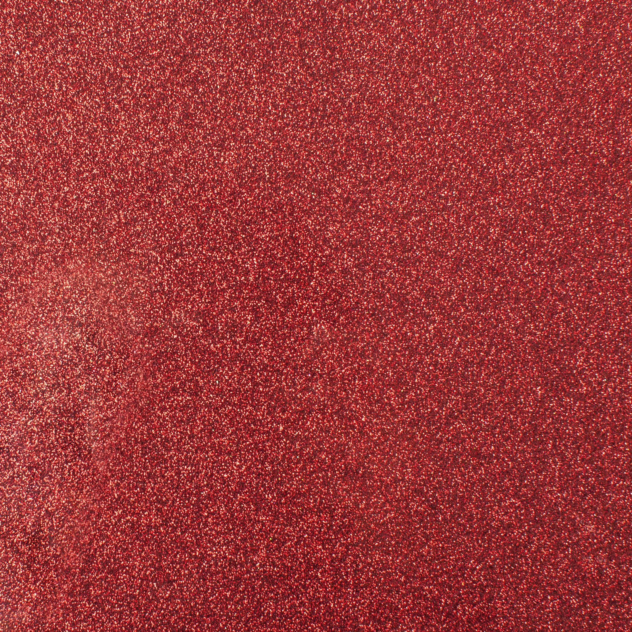 Nahaufnahme einer roten Glitzerfläche. Die Oberfläche ist stark reflektierend und glänzend.