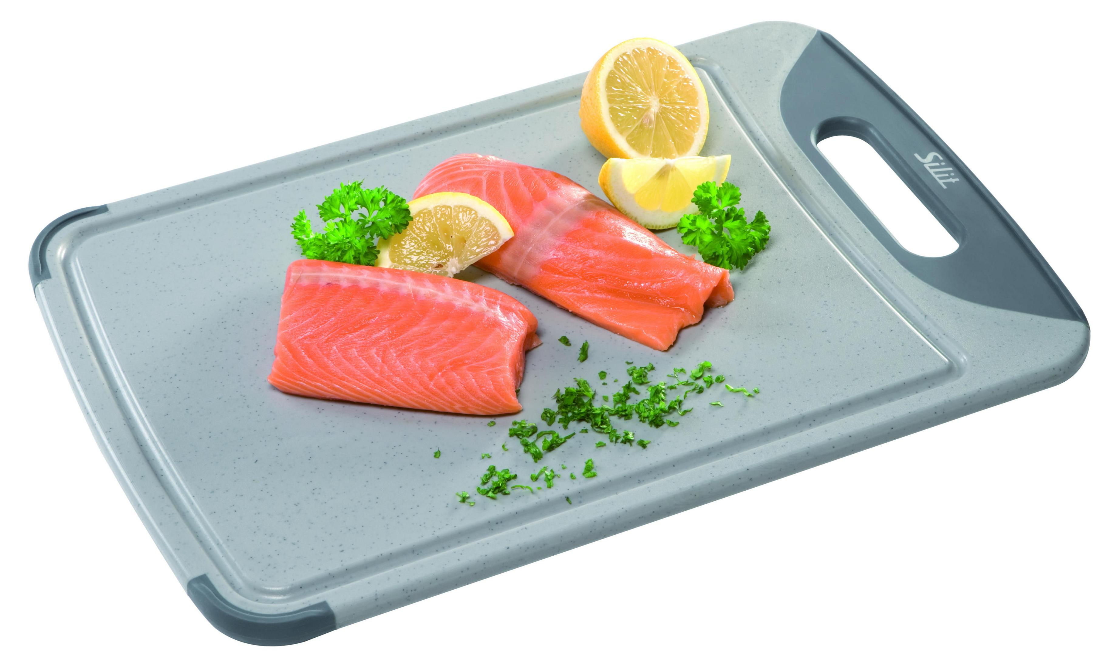 Lachsfilets und Zitronenscheiben auf einem grauen Schneidebrett mit Petersilie.