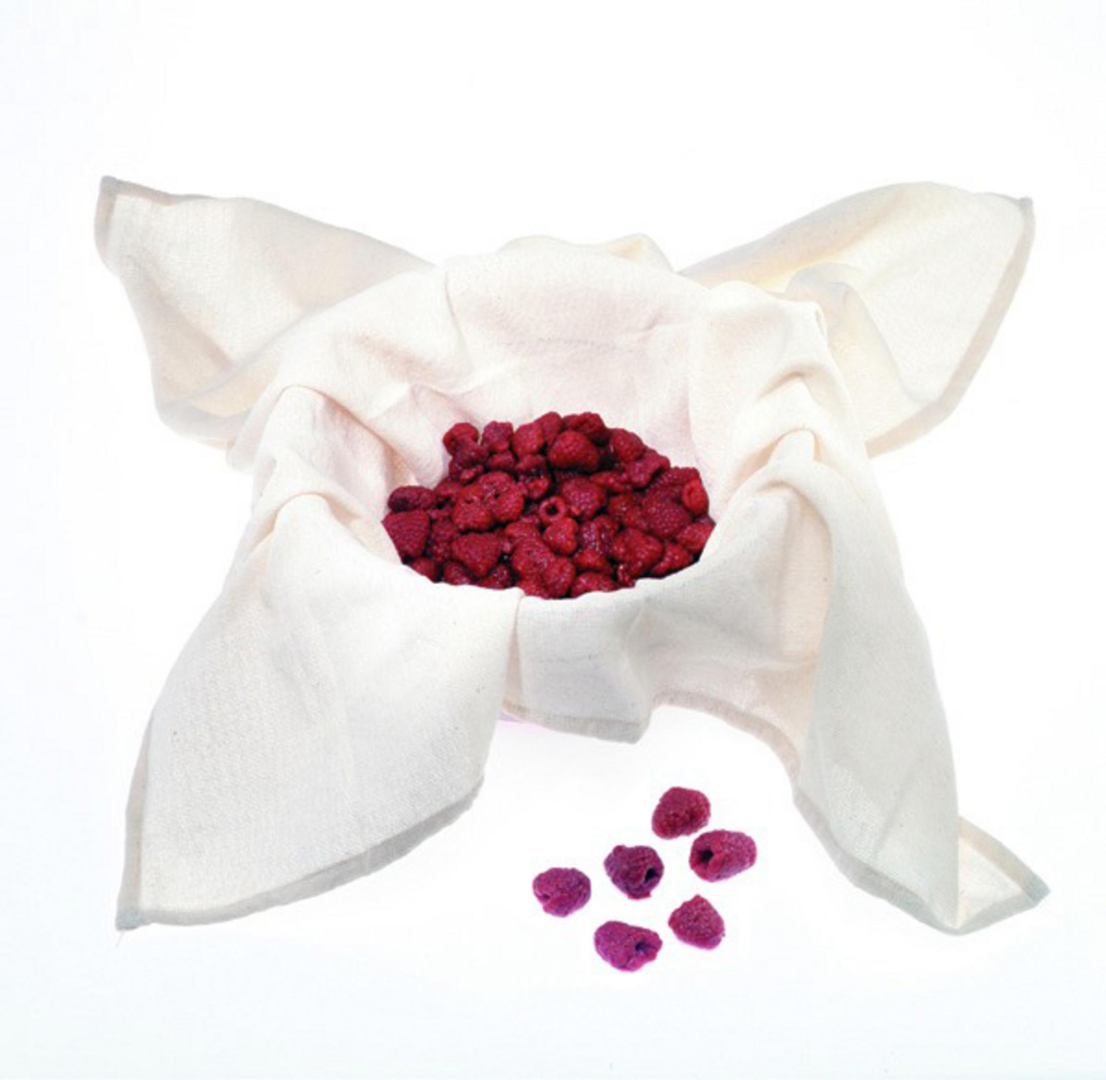Himbeeren in weißer Stoffschale, mit einigen losen Himbeeren, weißer Hintergrund.