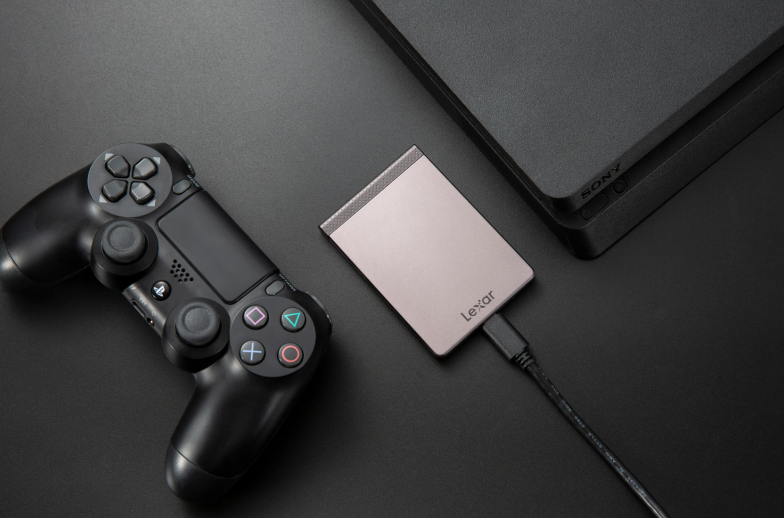 Kontroler do gier, zewnętrzny dysk twardy i konsola PlayStation 4, wszystko na ciemnej powierzchni.