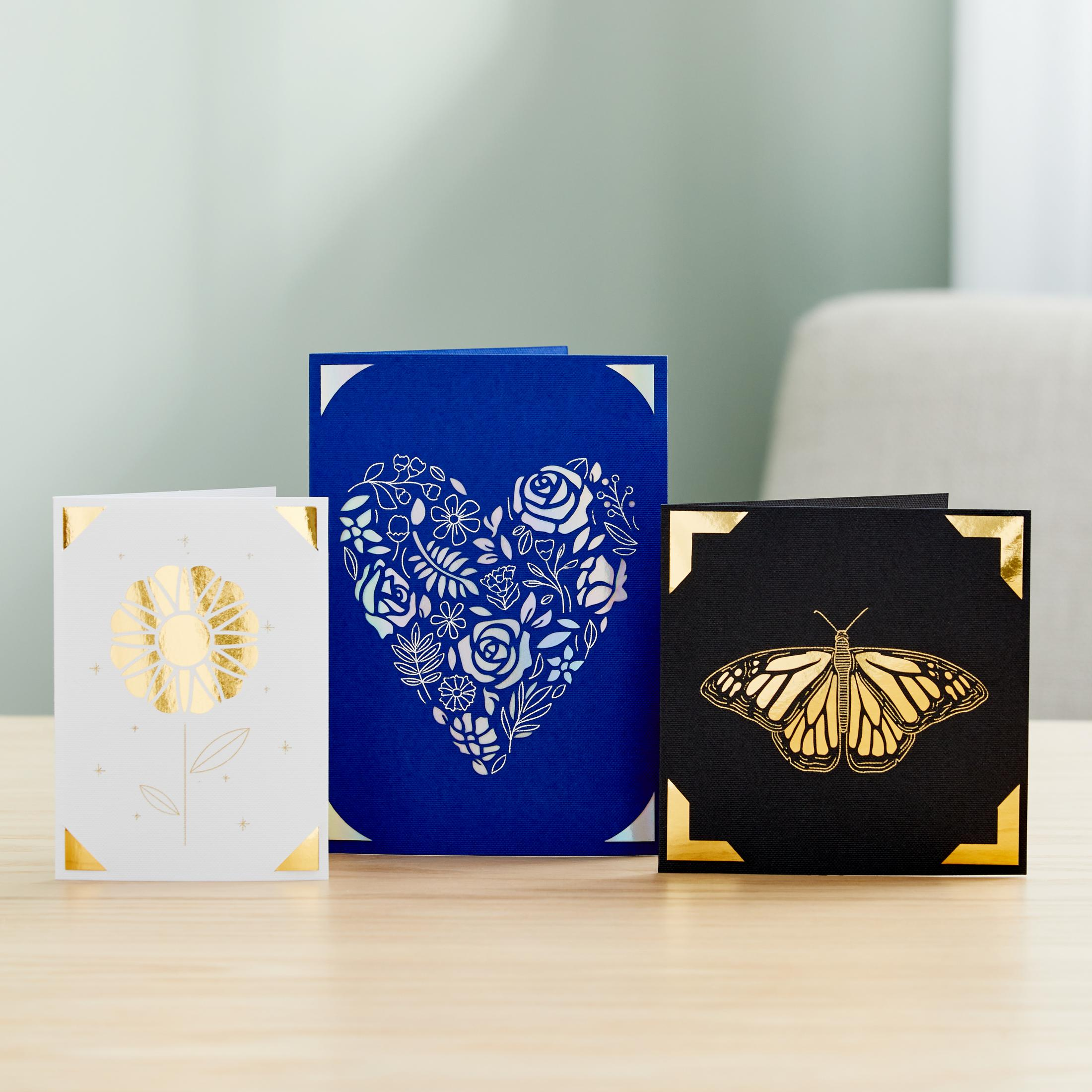 Drei Pop-up-Karten mit Goldakzenten. Eine Blume, ein Herz mit Rosen und ein Schmetterling.
