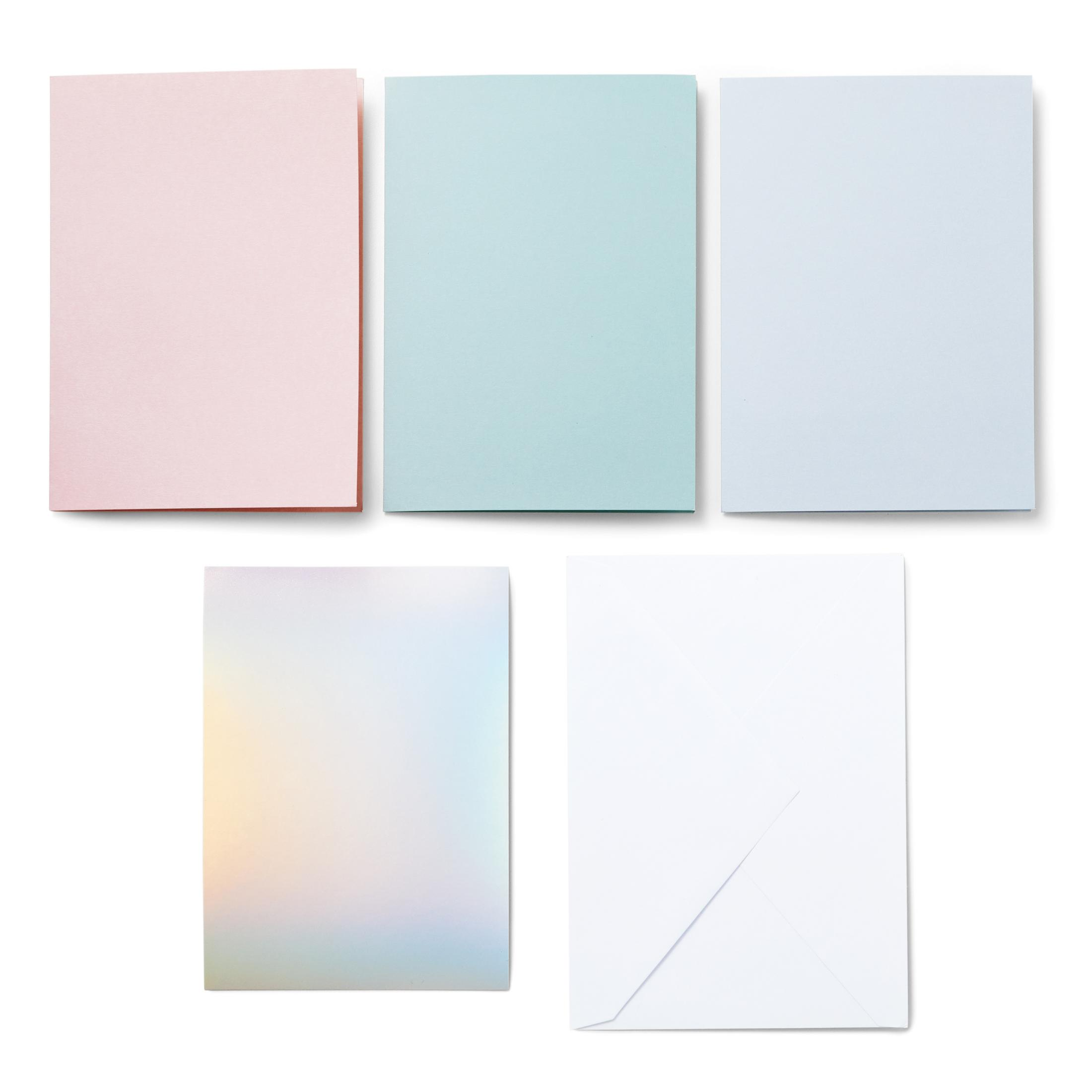 Fünf farbige Papiere auf weißem Untergrund. Farben: Rosa, Blau, Hellblau, Irisierend und Weiß.