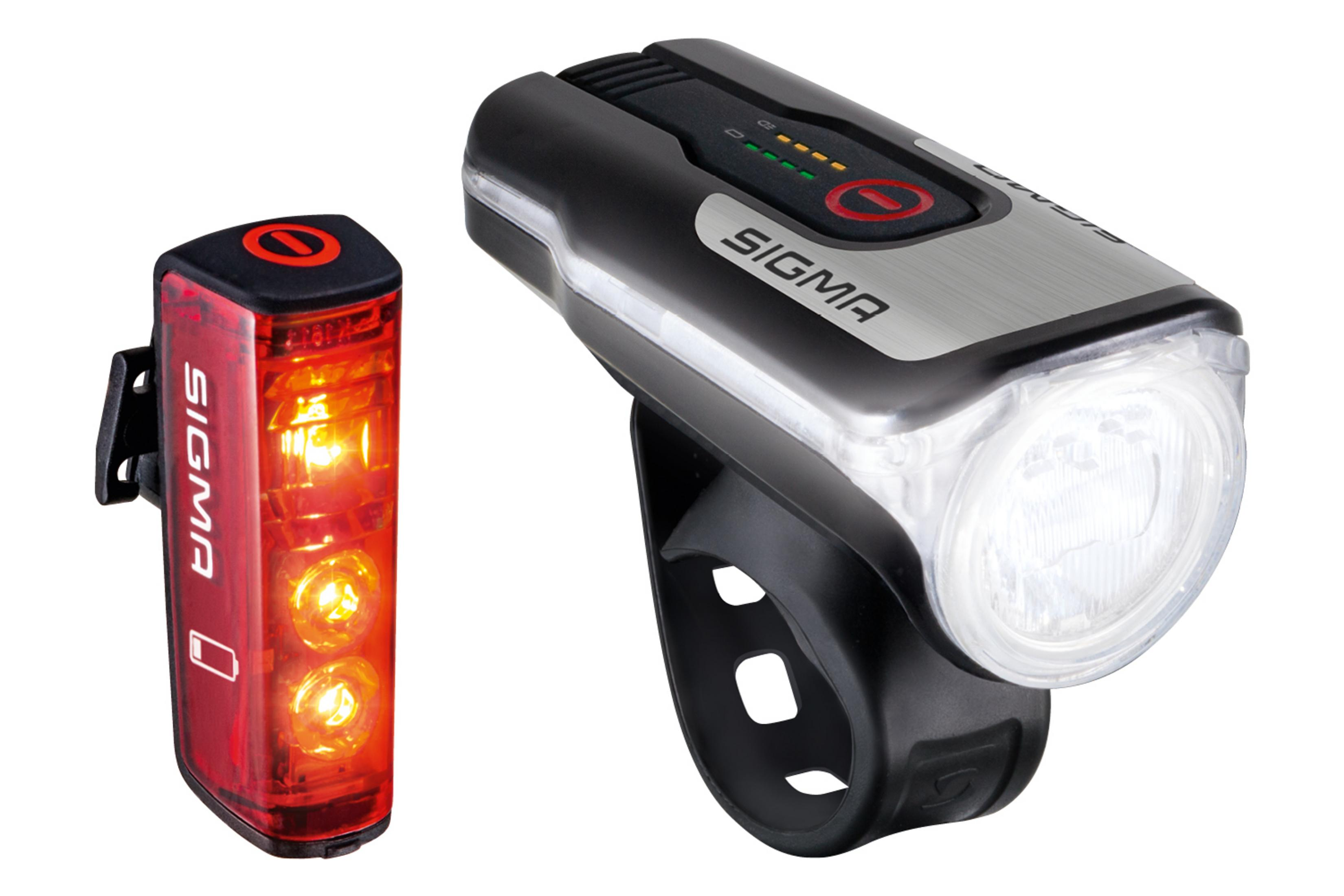Dwa światła rowerowe, jedno czerwone i czarne ze srebrną górą. Oba z logo Sigma.