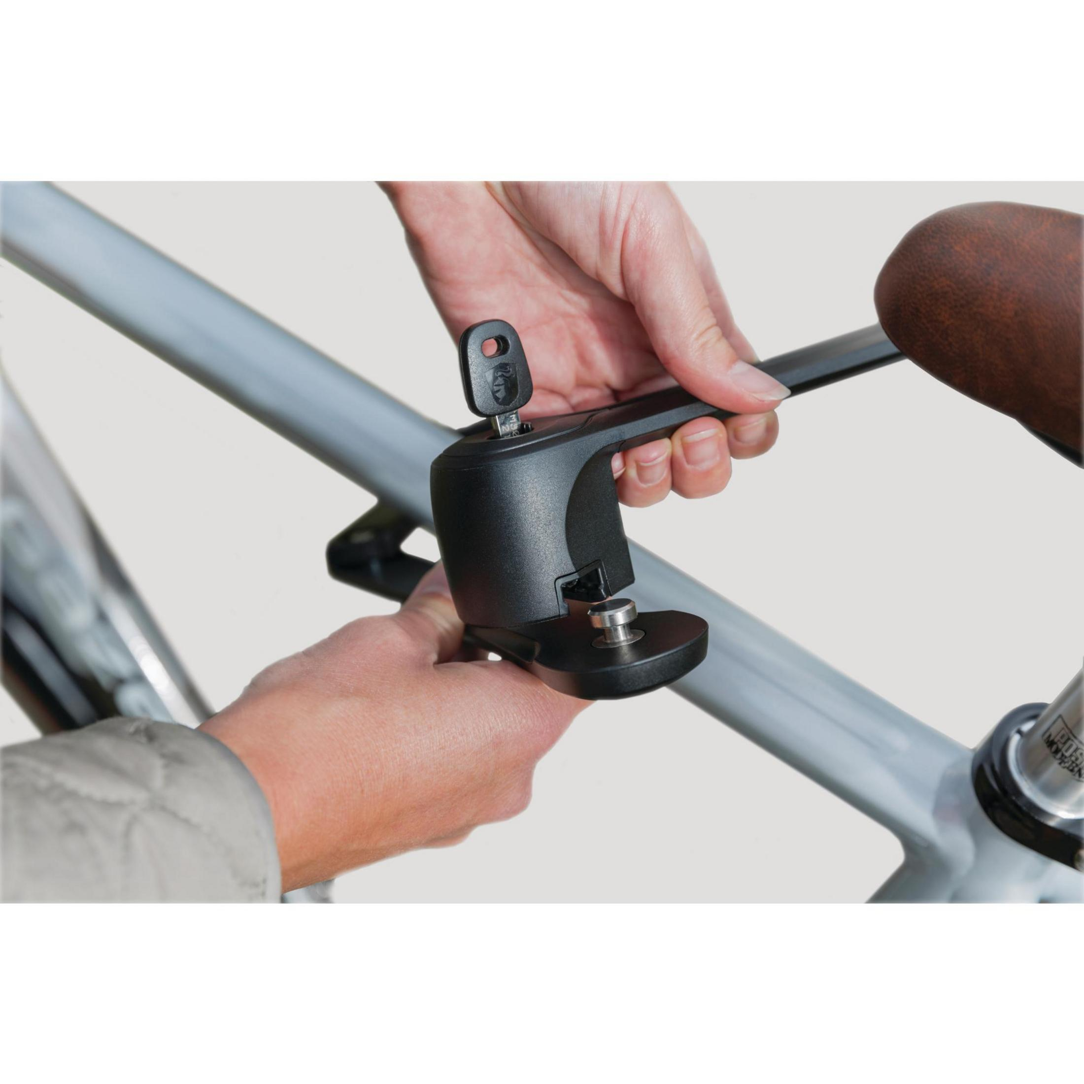 Hände benutzen ein schwarzes Fahrradschloss an einem grauen Rahmen.