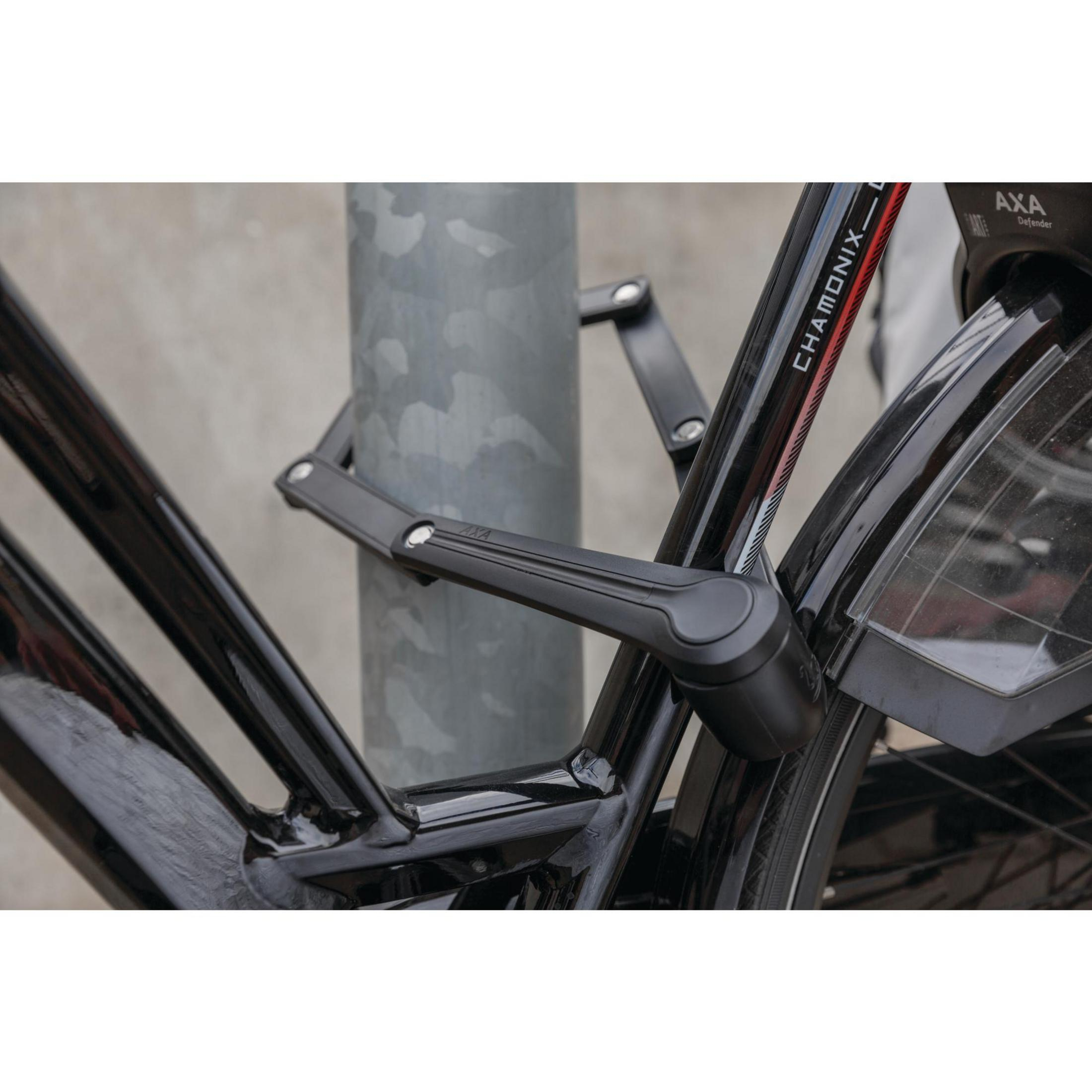 Schwarzes Fahrradschloss um eine Stange und einen Fahrradrahmen.