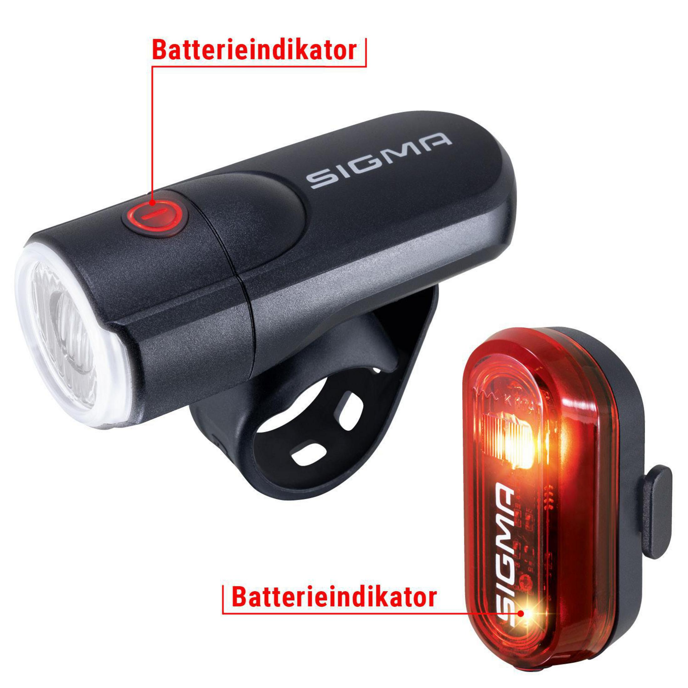 Dwa światła rowerowe, jedno czarne, drugie czerwone, oba z logo Sigma i wskaźnikiem baterii.