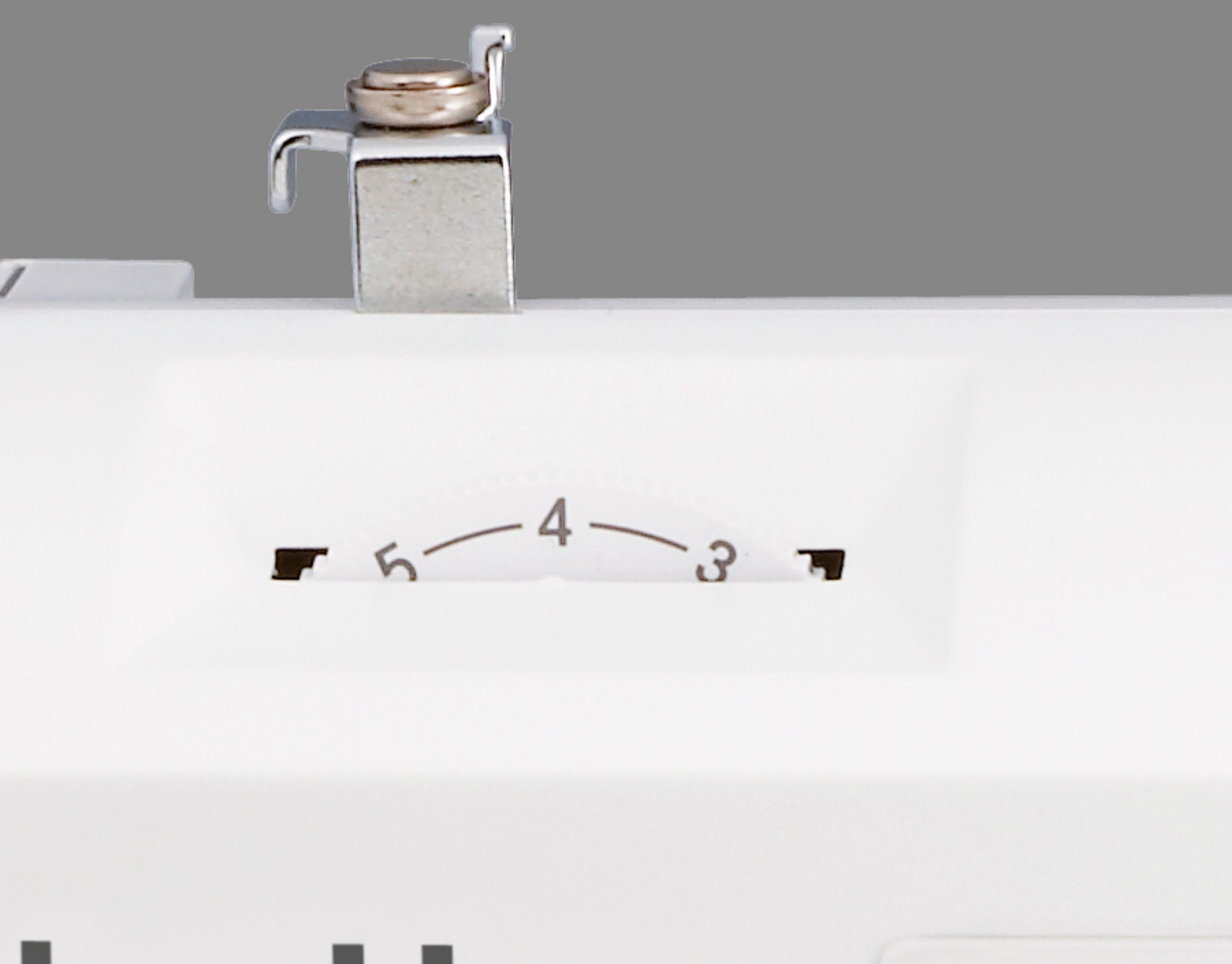 Zbliżenie pokrętła maszyny do szycia, widoczne liczby 3-5.