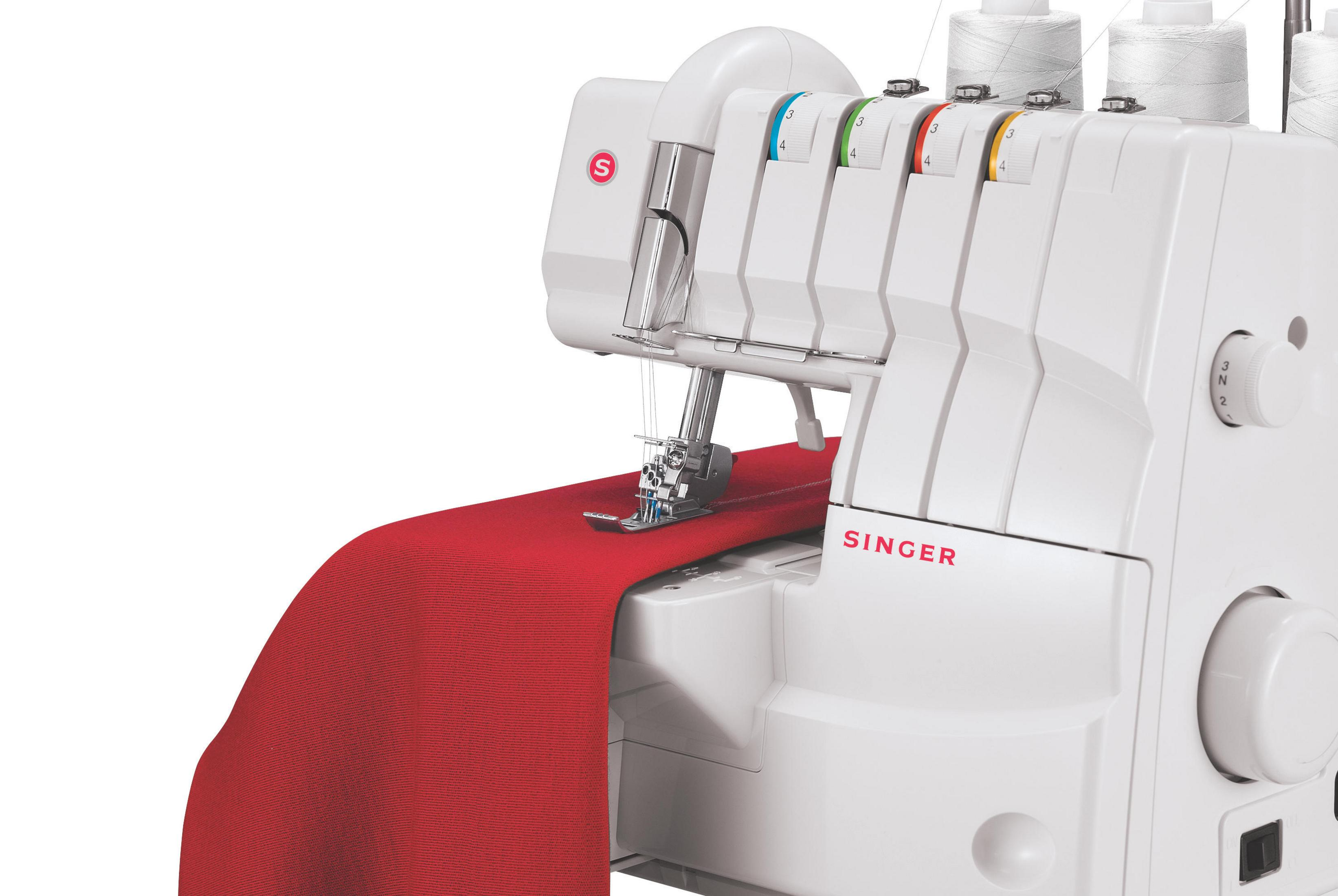 Macchina overlock Singer bianca. Tessuto rosso cucito. Dettagli della macchina visibili. Sfondo bianco.