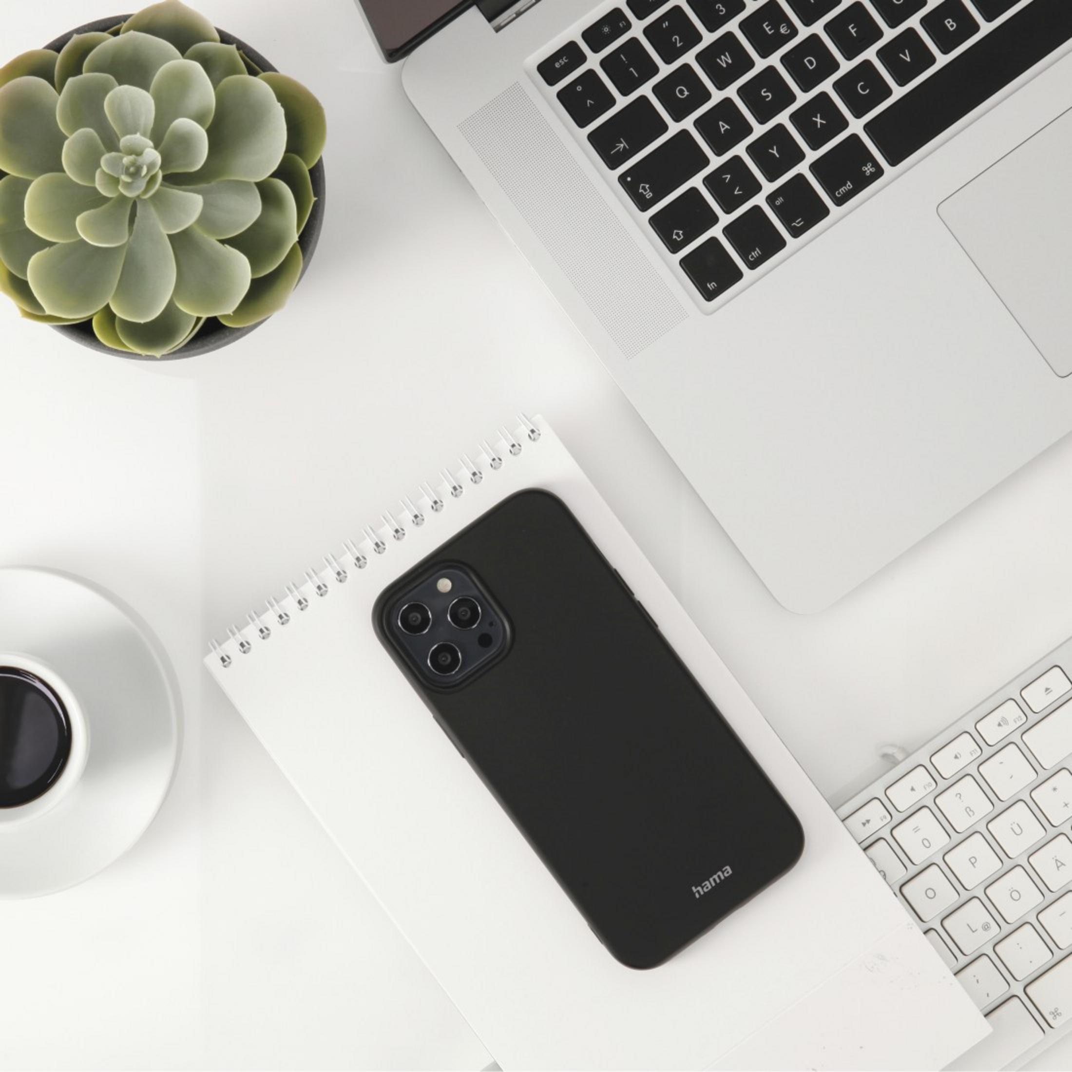 Widok z góry na biurko z laptopem, etui na telefon, notatnikiem, sukulentem i kawą.