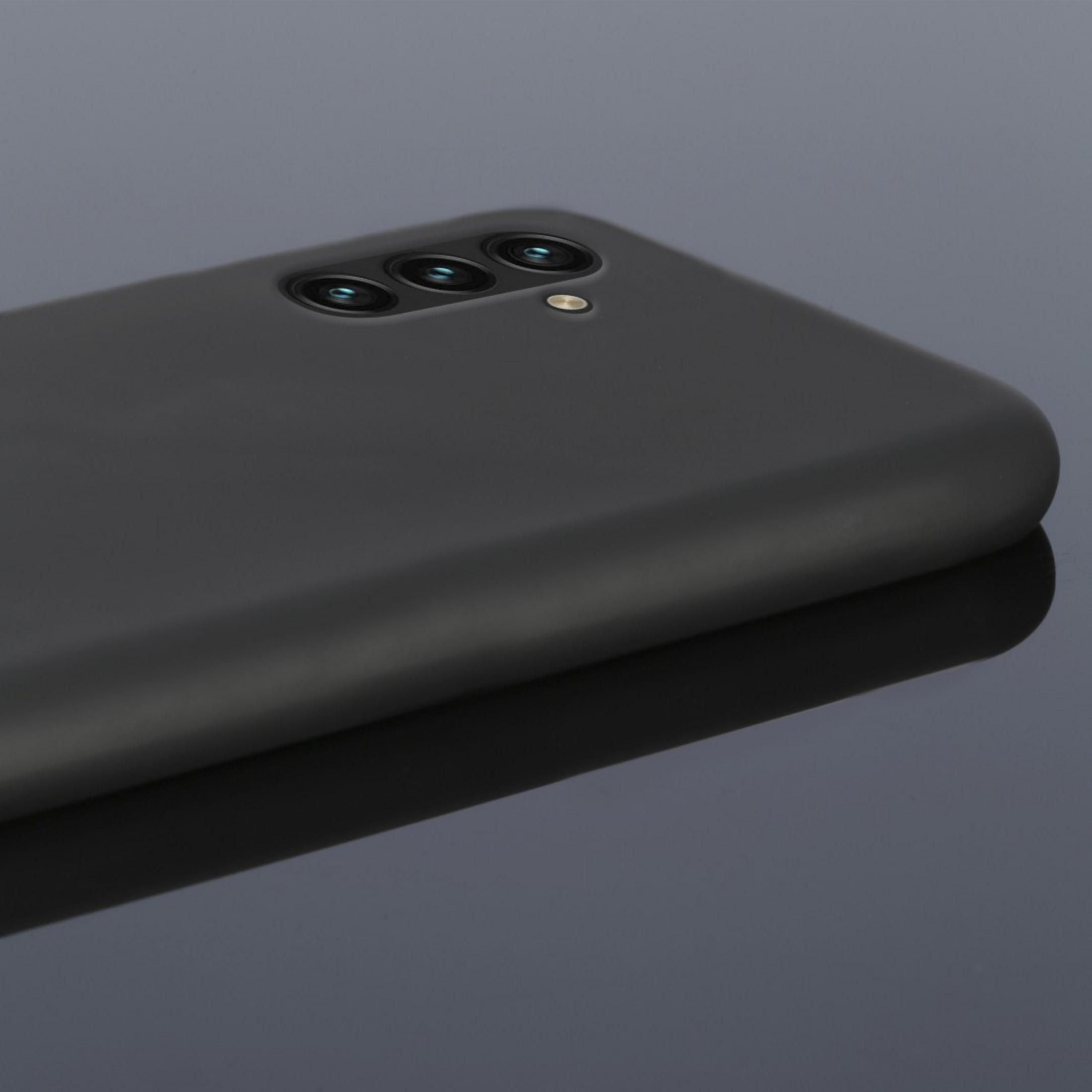 Custodia per telefono nera con tre lenti della fotocamera. Il telefono è su una superficie riflettente.