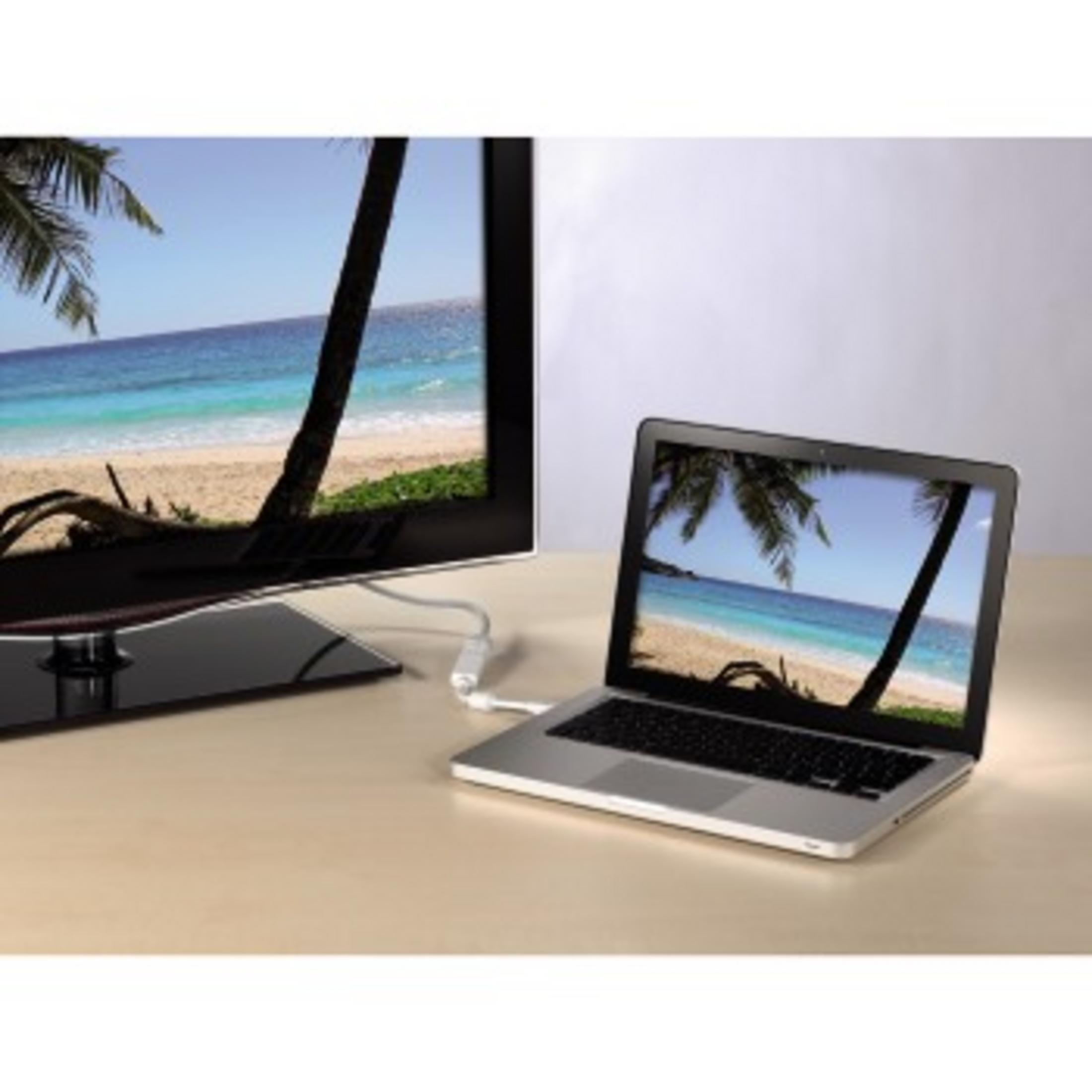 Laptop mit Fernseher verbunden. Strandbild auf beiden Bildschirmen. Auf einem Holztisch.