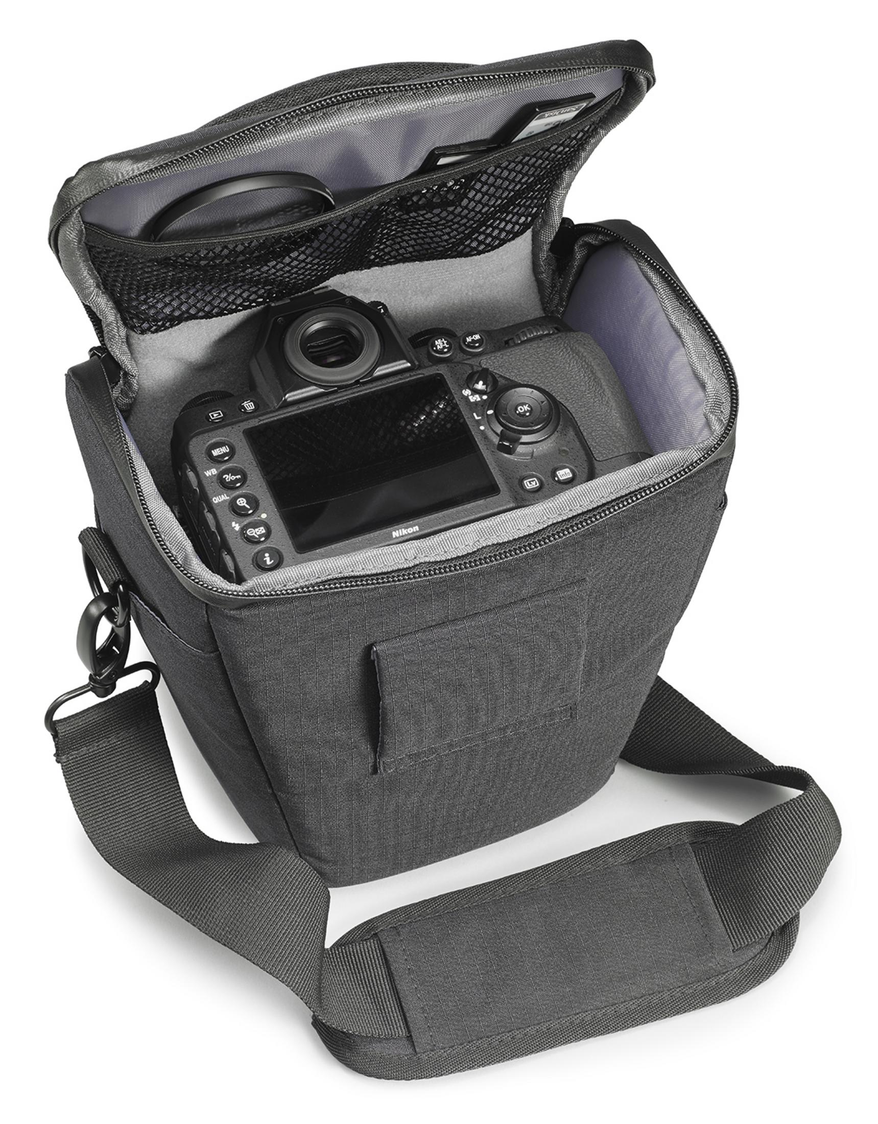 Kamera in einer schwarzen Tasche. Die Tasche ist offen. Grauer Innenraum. Weißer Hintergrund.
