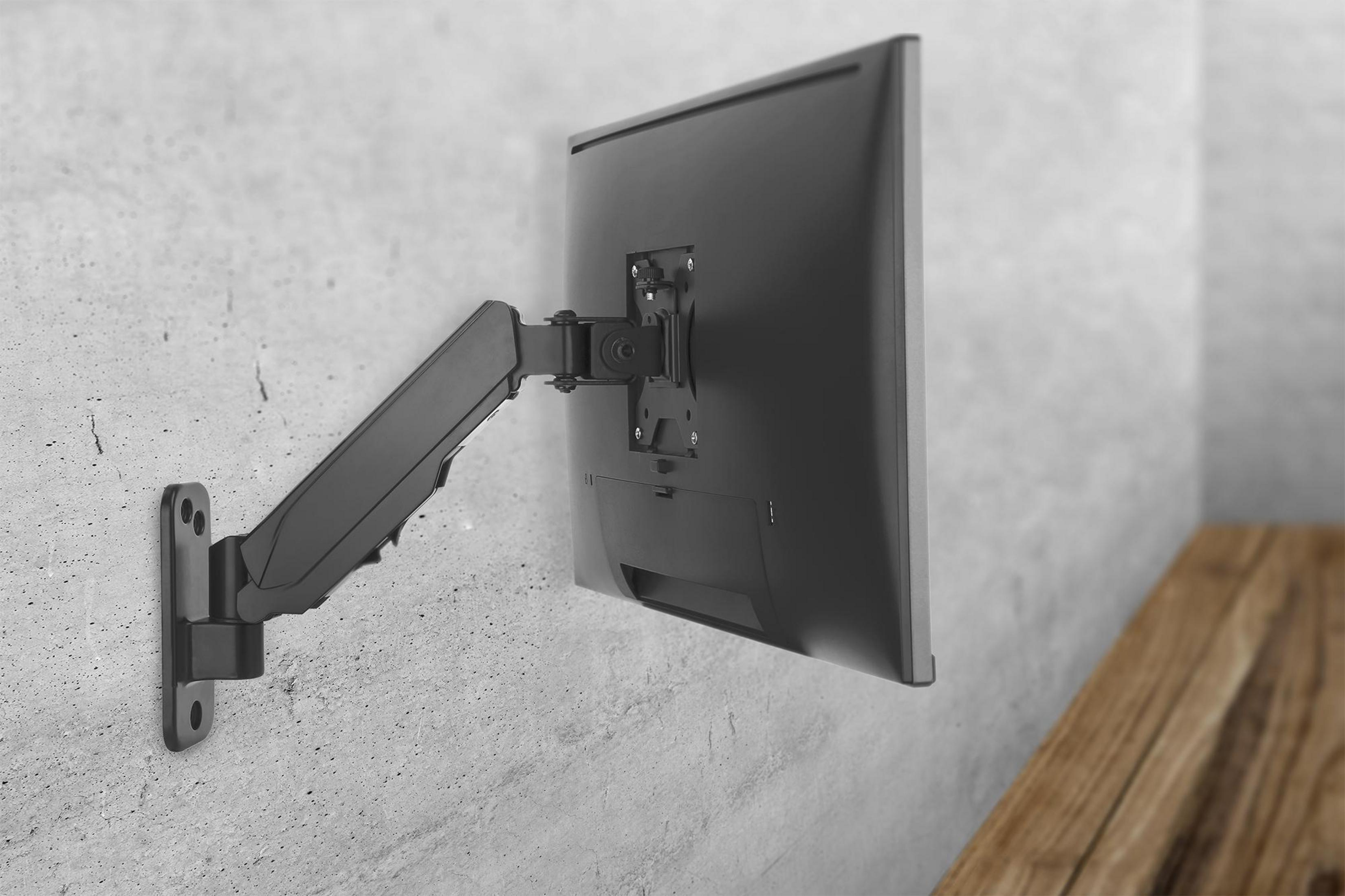 Ein schwarzer Monitorarm an einer Wand mit einem Monitor darauf.