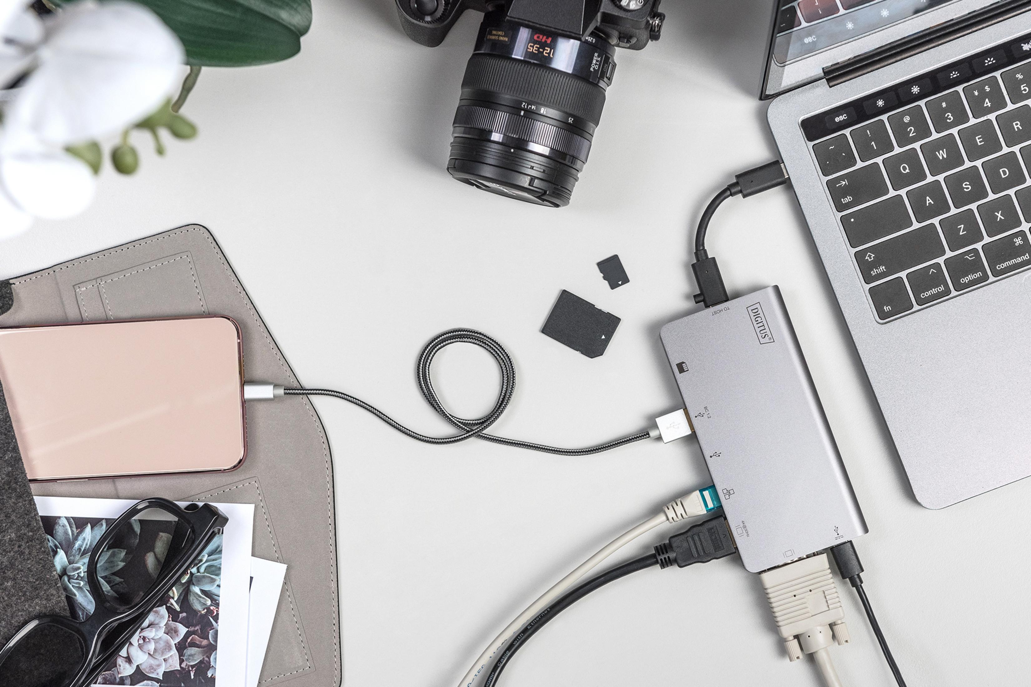 Un'installazione da scrivania con una fotocamera, un laptop e un hub. Sfondo bianco.