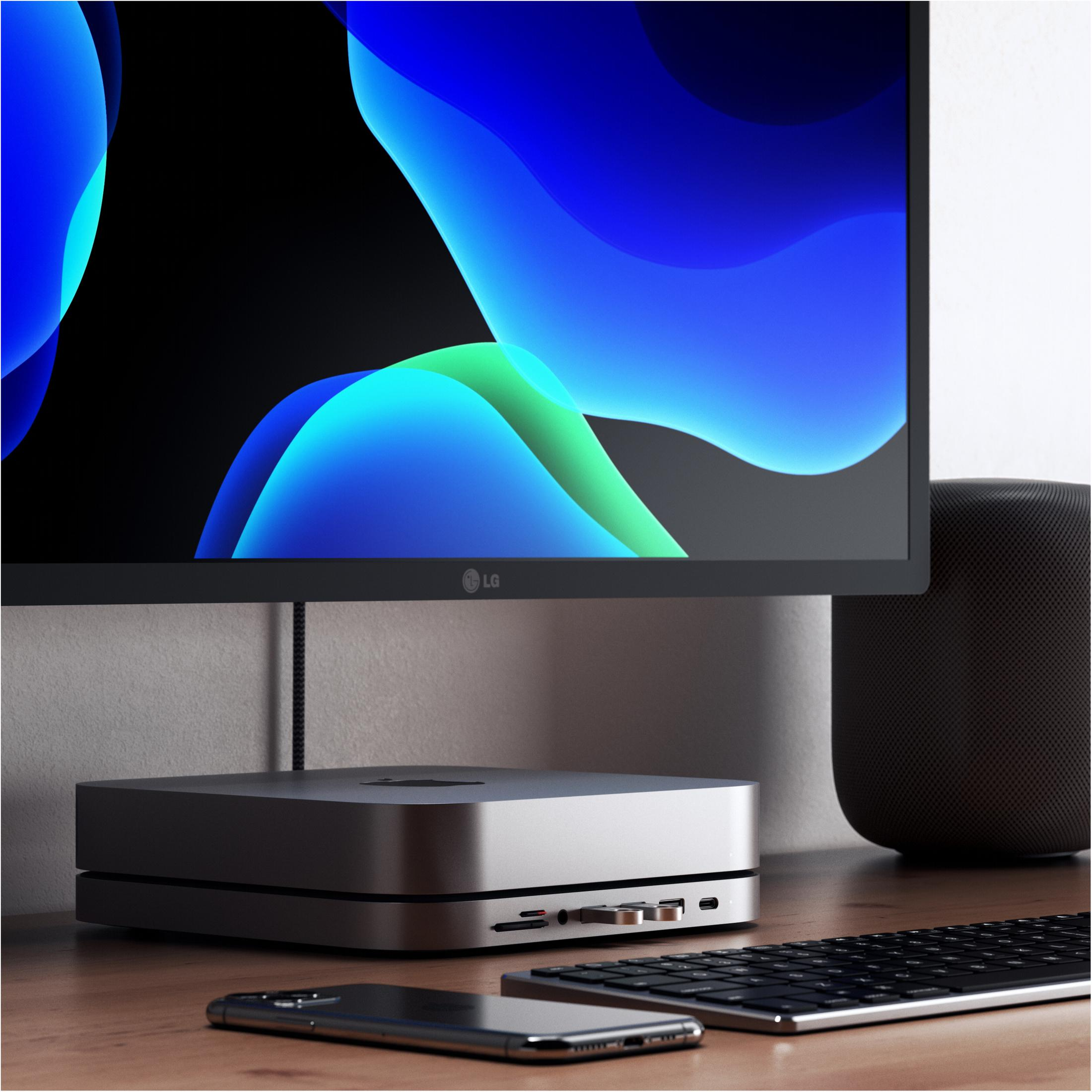 Computer-Setup: Monitor, Mac Mini, Tastatur, Telefon. Minimalistischer Stil.