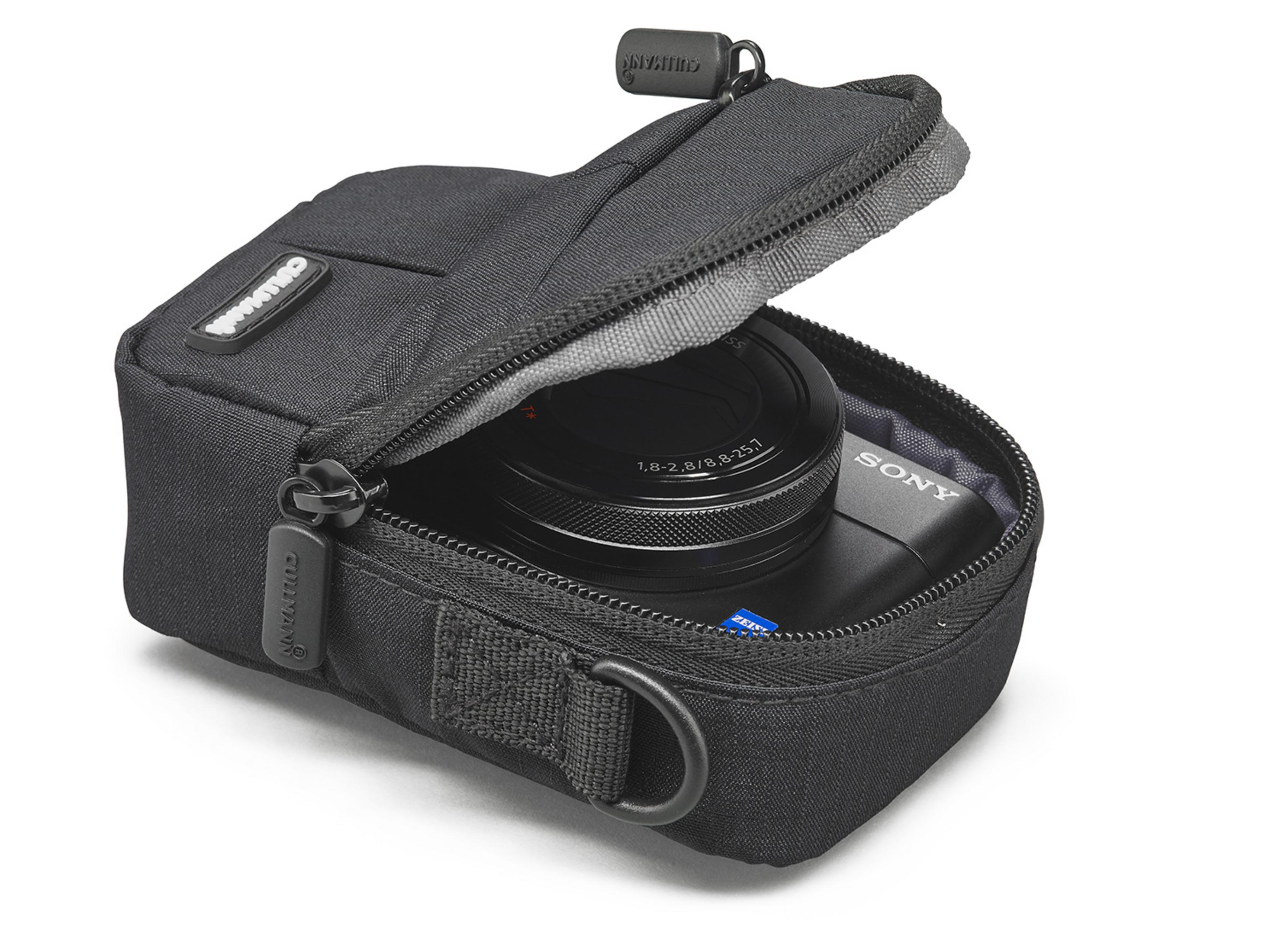 Schwarze Kamera in schwarzer Tasche, teilweise geöffnet. Weißer Hintergrund.