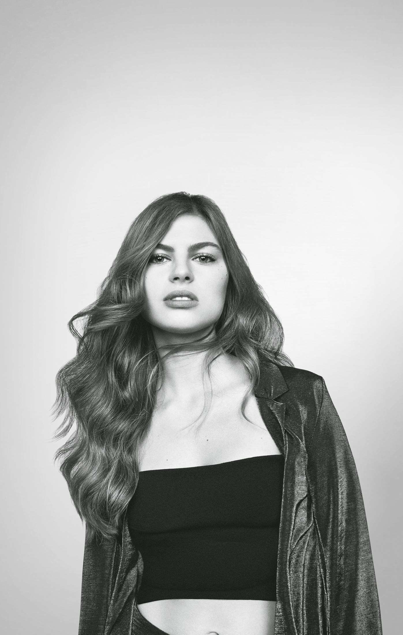 Czarno-biały portret kobiety w kurtce i topie.