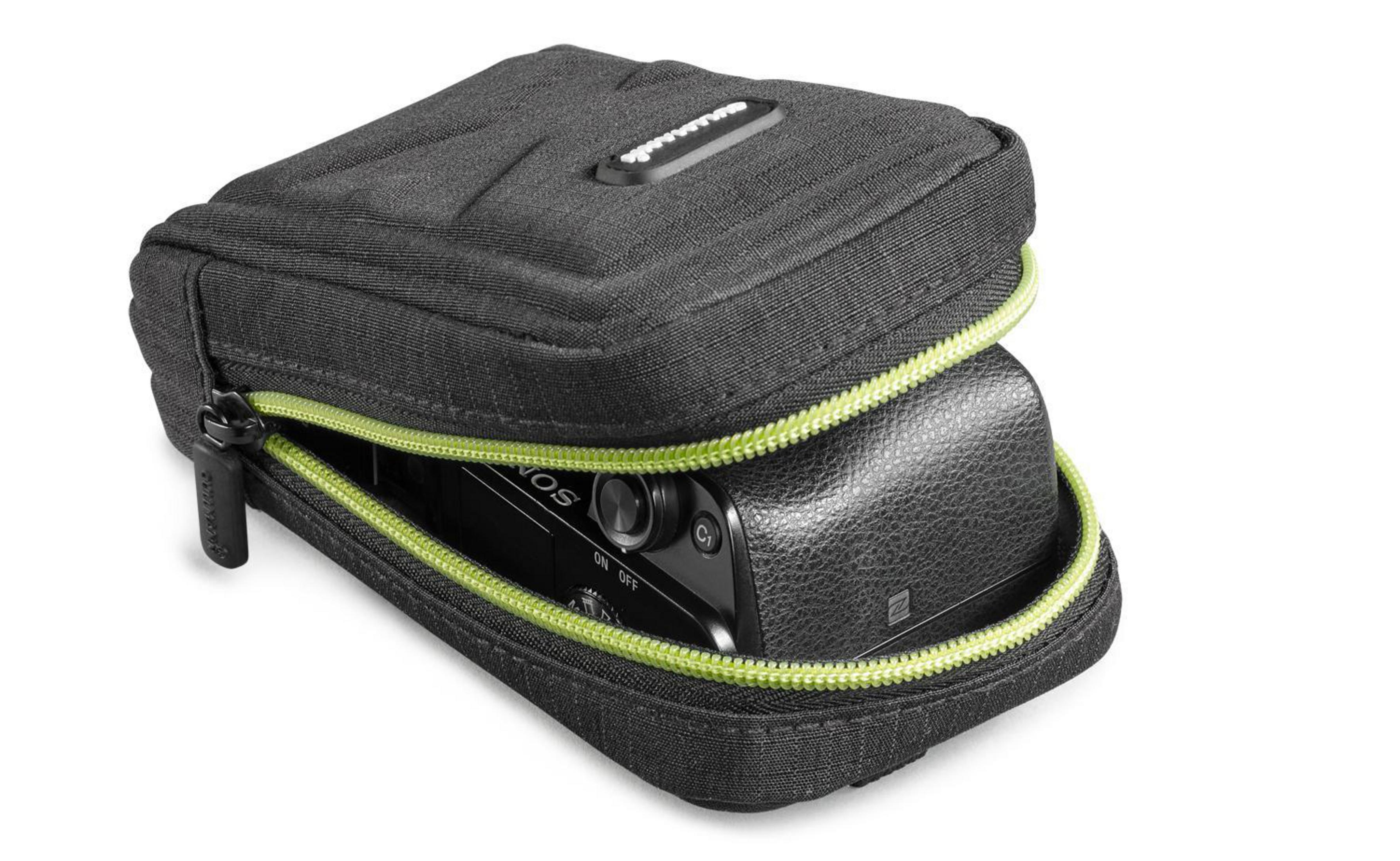 Eine schwarze Kamera befindet sich in einer schwarzen Tasche mit grünem Reißverschluss auf weißem Hintergrund.