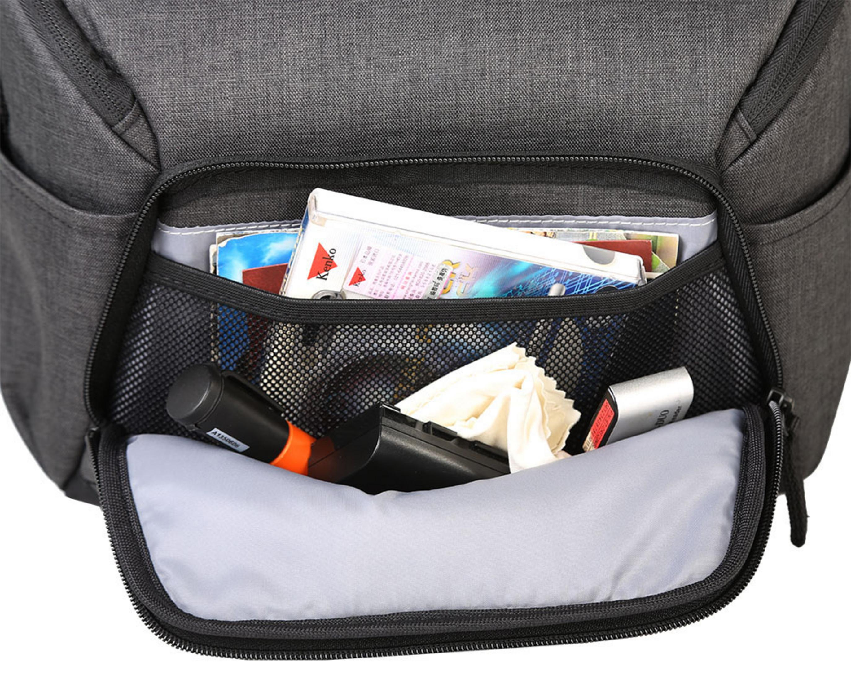 Bolsillo abierto de una mochila con varios objetos: pañuelos, cigarrillos y un micrófono.