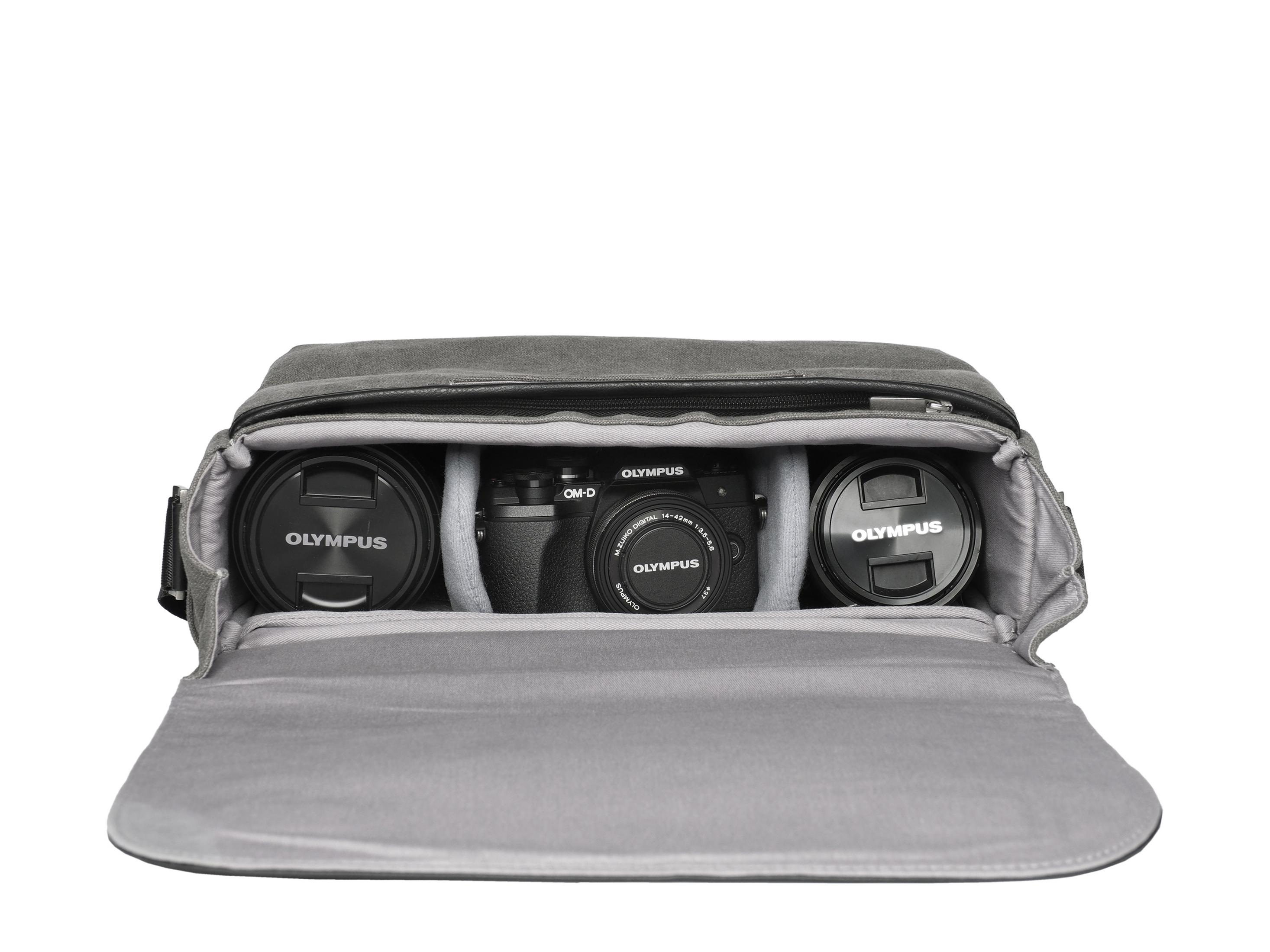 Borsa grigia con obiettivi e fotocamera all'interno, su sfondo bianco.