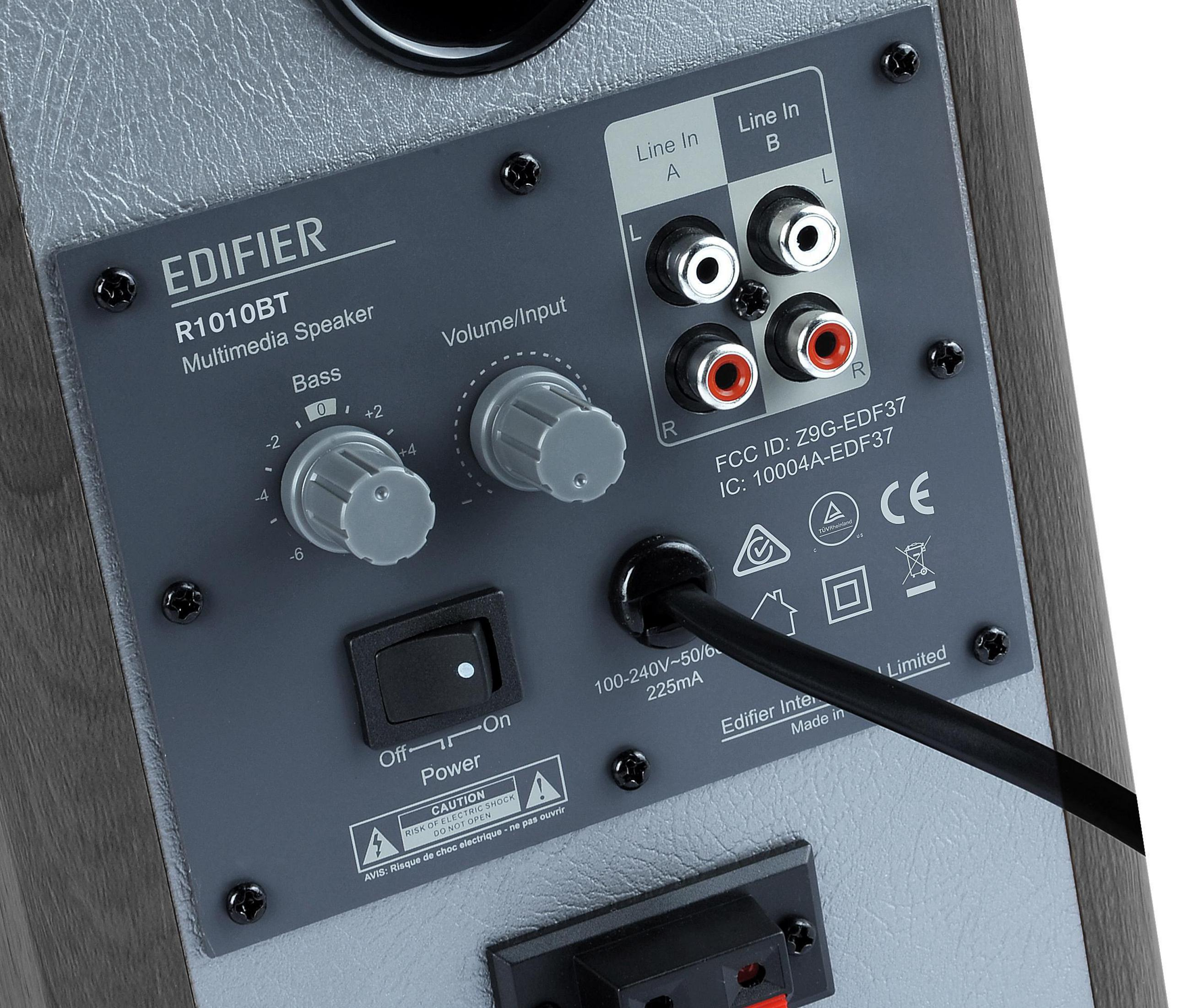 Zbliżenie tylnego panelu czarno-szarego głośnika. Pokazuje wejścia i porty.