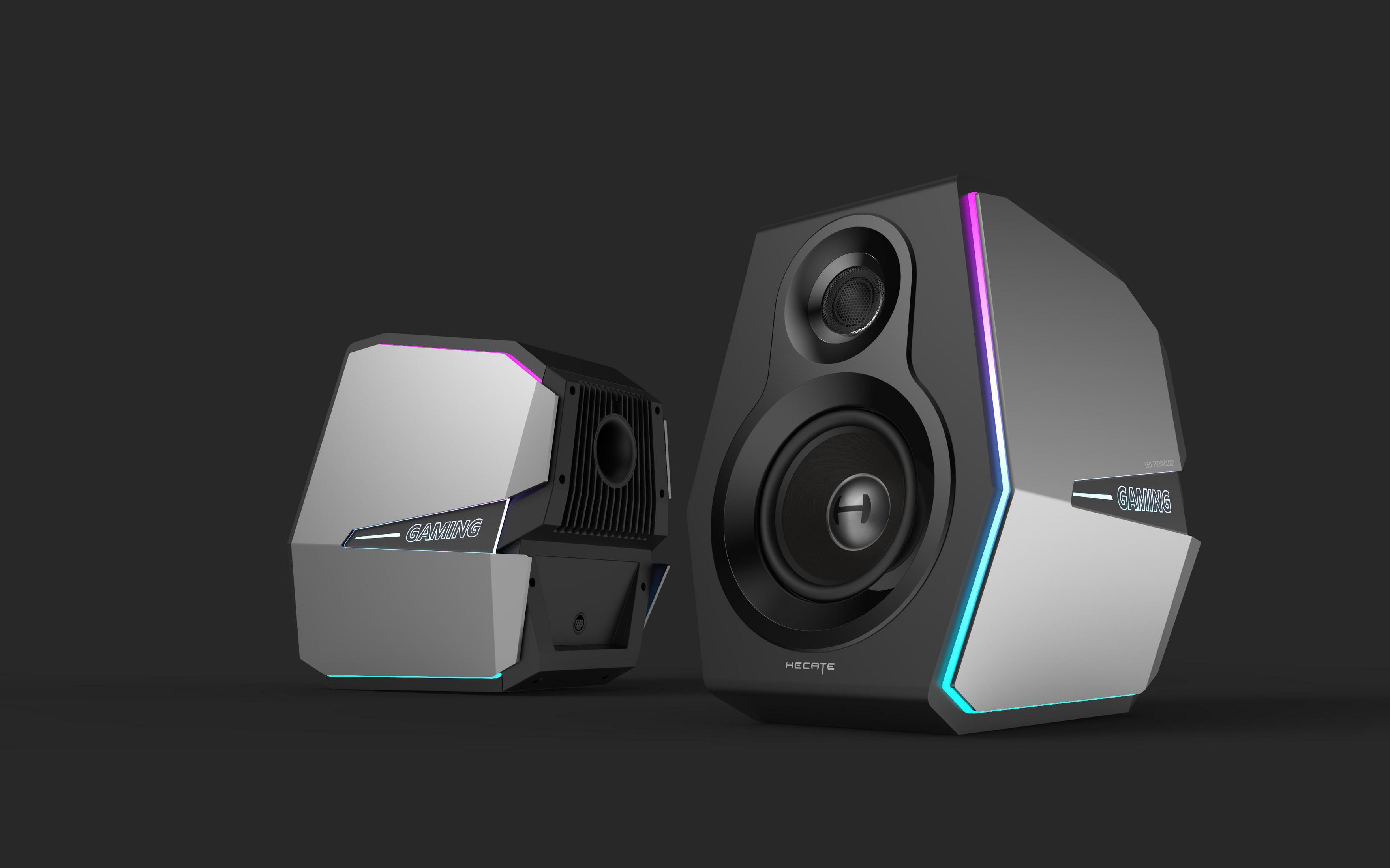 Due altoparlanti gaming. Nero, argento e illuminazione RGB su sfondo scuro.
