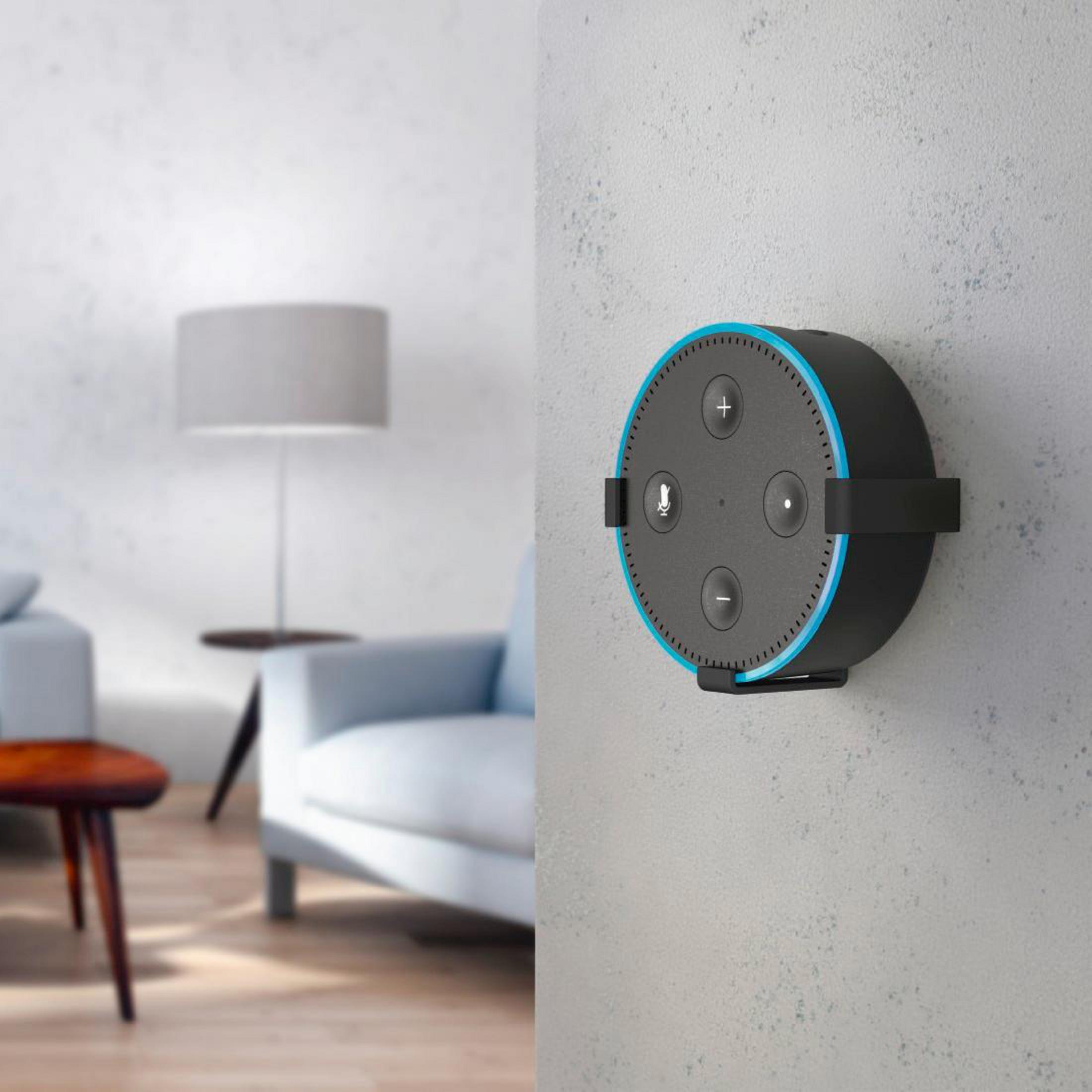 Altoparlante intelligente nero su muro bianco. Lampada e mobili sfocati sullo sfondo.