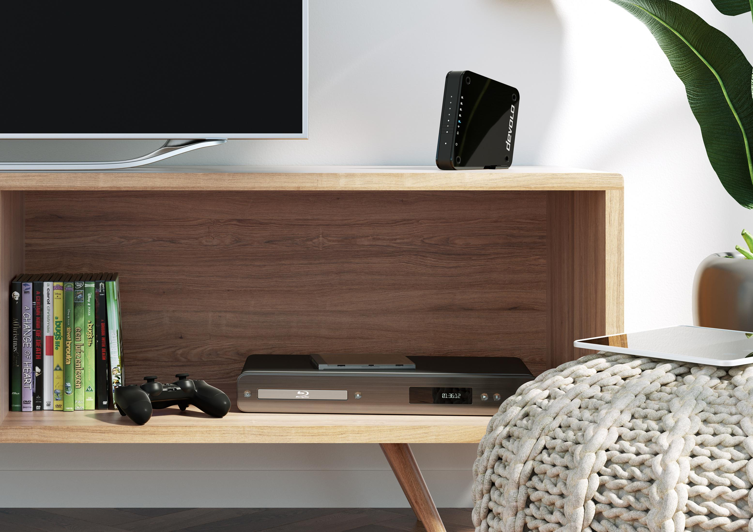 Ein TV-Ständer mit einem Fernseher, einem DVD-Player, einer Spielkonsole und einigen Büchern.