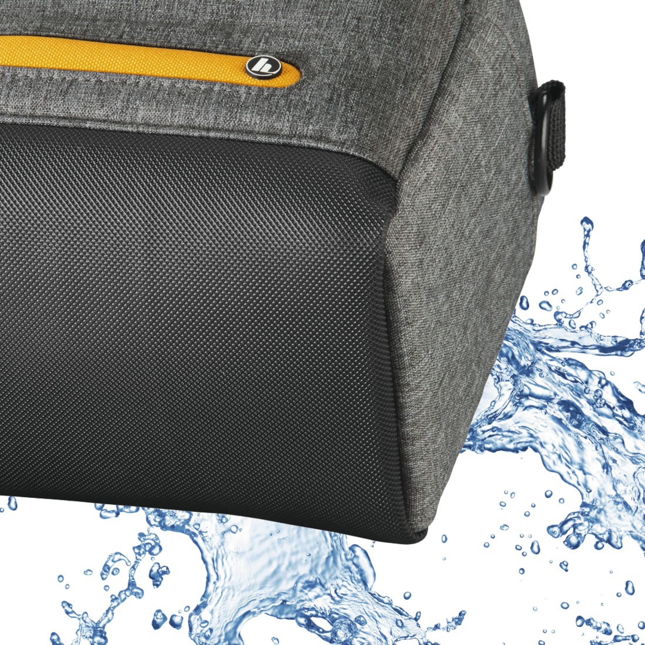 Zbliżenie szarej i czarnej torby z żółtym zamkiem błyskawicznym. Krople wody na pierwszym planie.