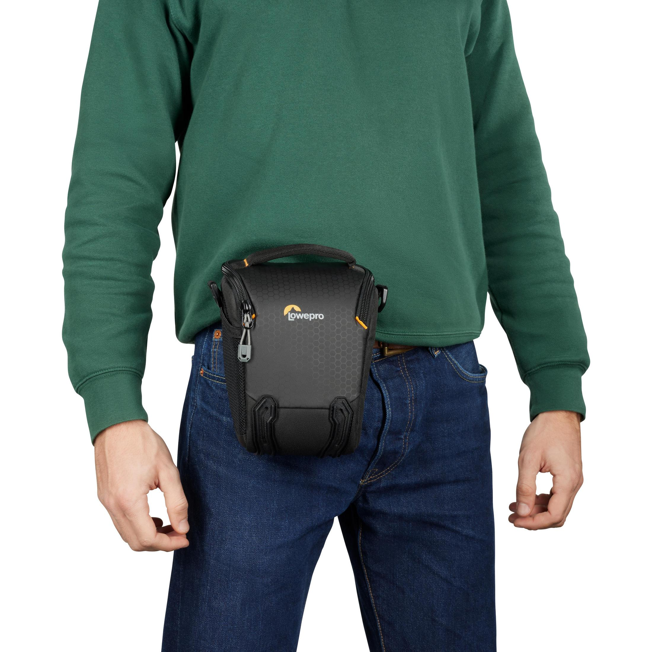Person with a black camera bag around their waist. White background.