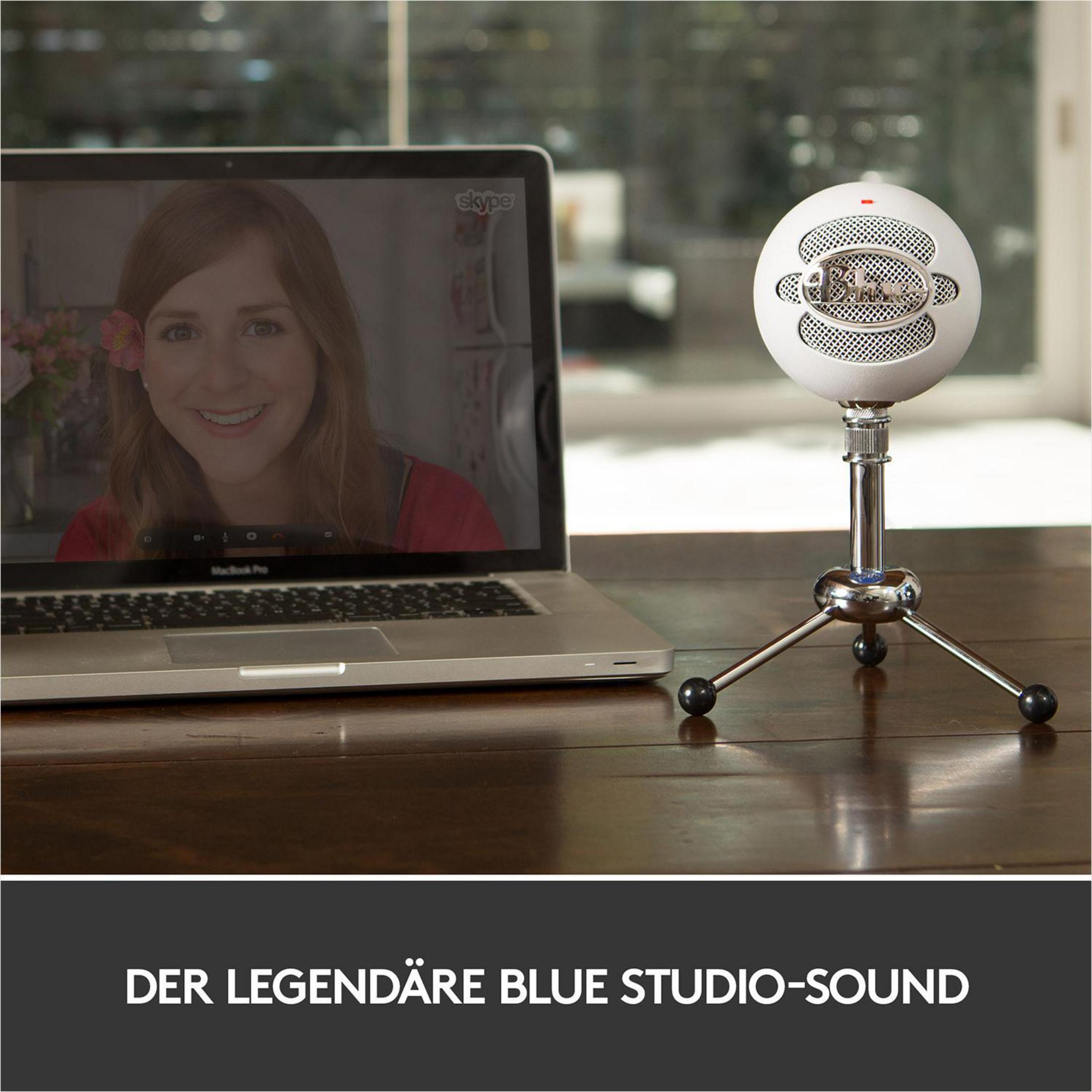 Frau im Videoanruf auf Laptop. Weißes Mikrofon auf Stativ.
