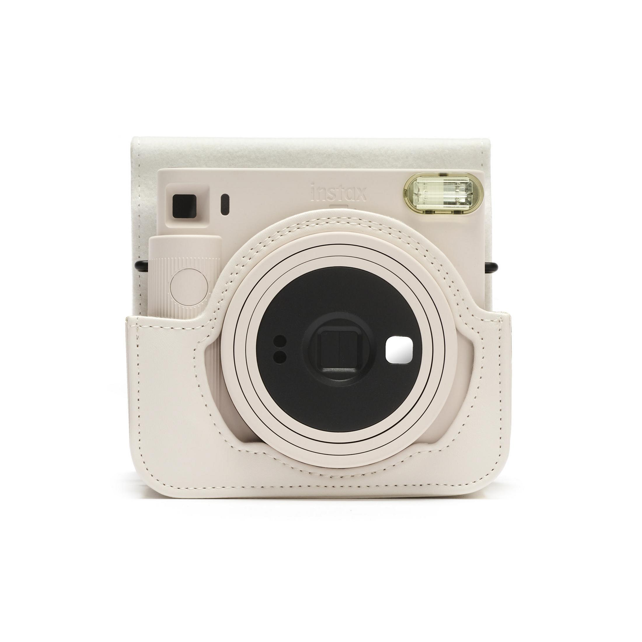 Cámara Instax color crema en una funda de cuero crema, con flash y lente.