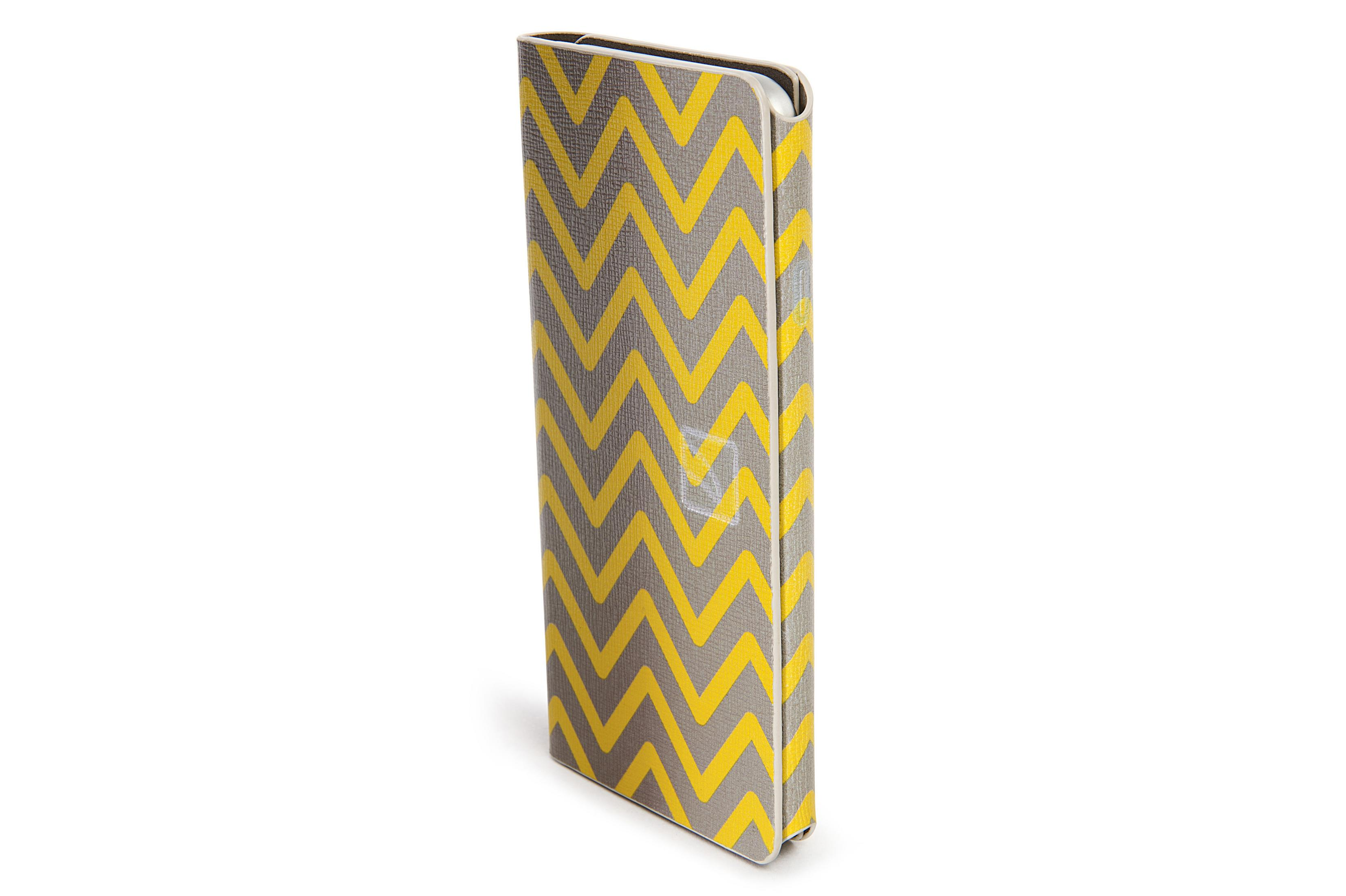 Quaderno chiuso con un motivo a zigzag giallo e grigio su sfondo bianco.