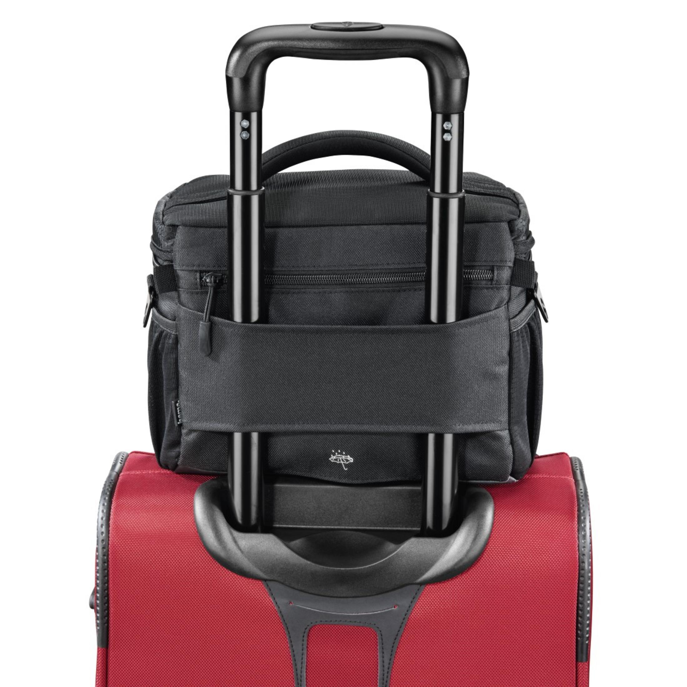 Schwarze Reisetasche mit schwarzem Griff auf rotem Koffer. Beide auf weißem Hintergrund.
