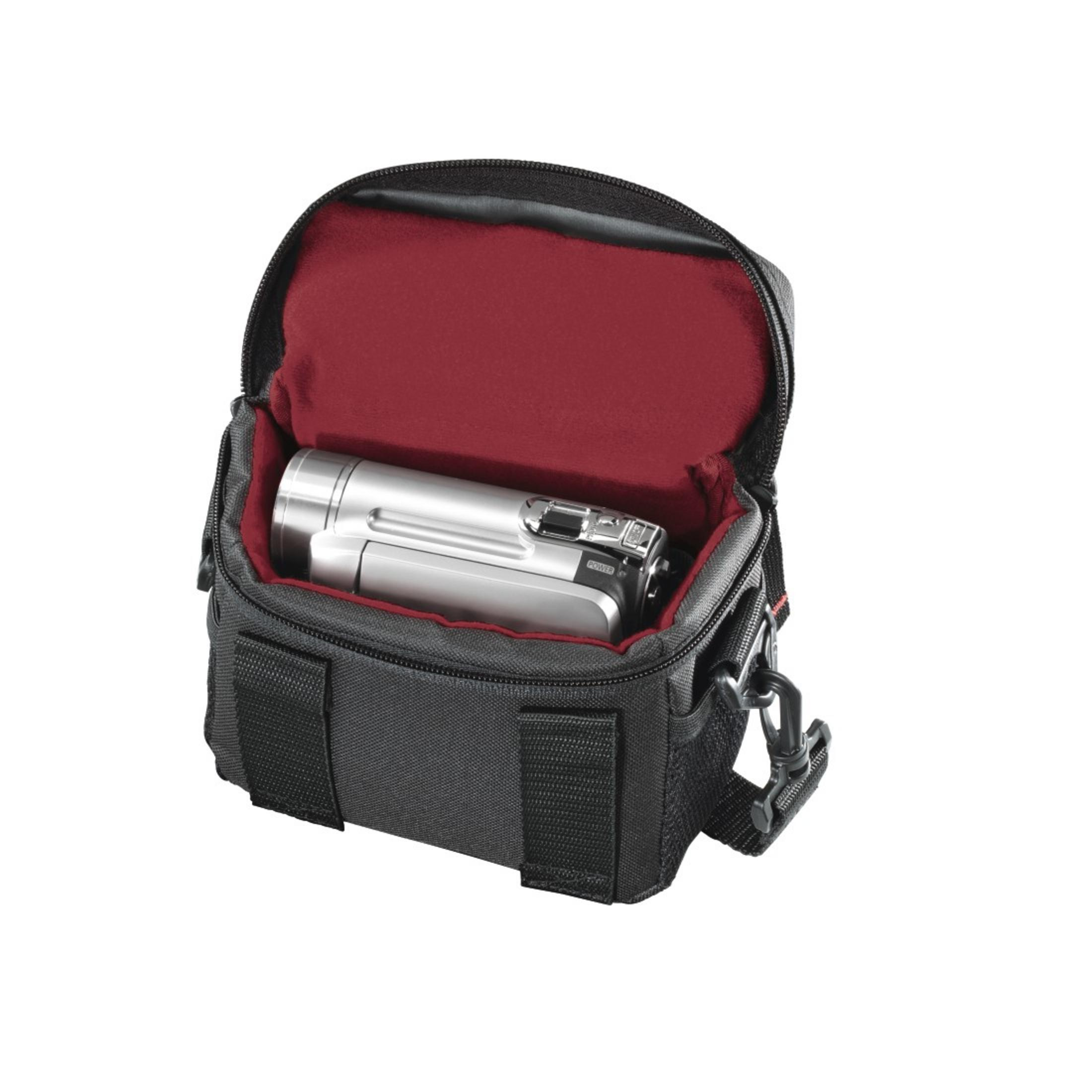 Eine schwarze Kameratasche mit rotem Innenraum, die eine silberne Kamera hält. Die Tasche ist offen.