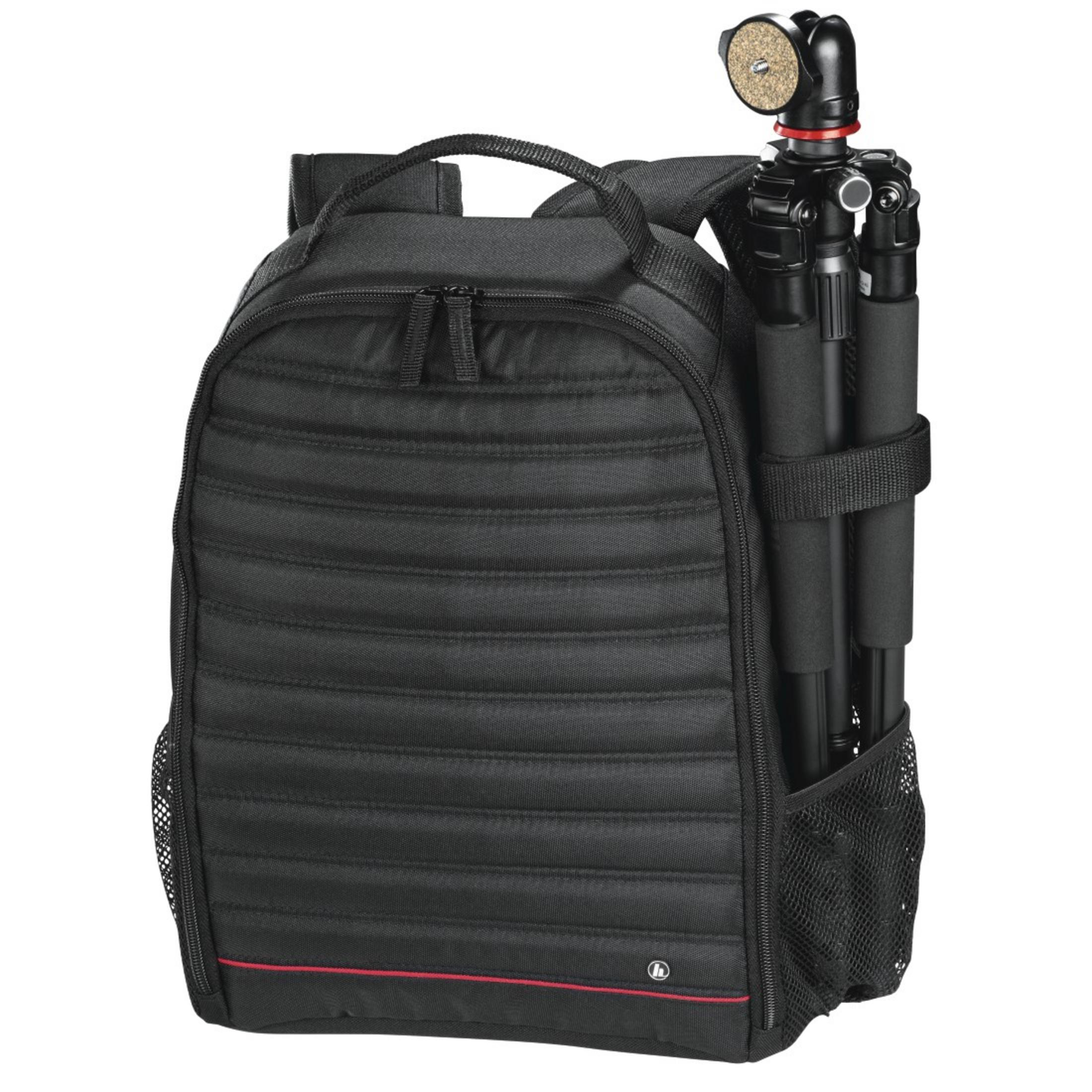 Schwarzer Rucksack mit Stativ in der Seitentasche und roter Linie am Boden.