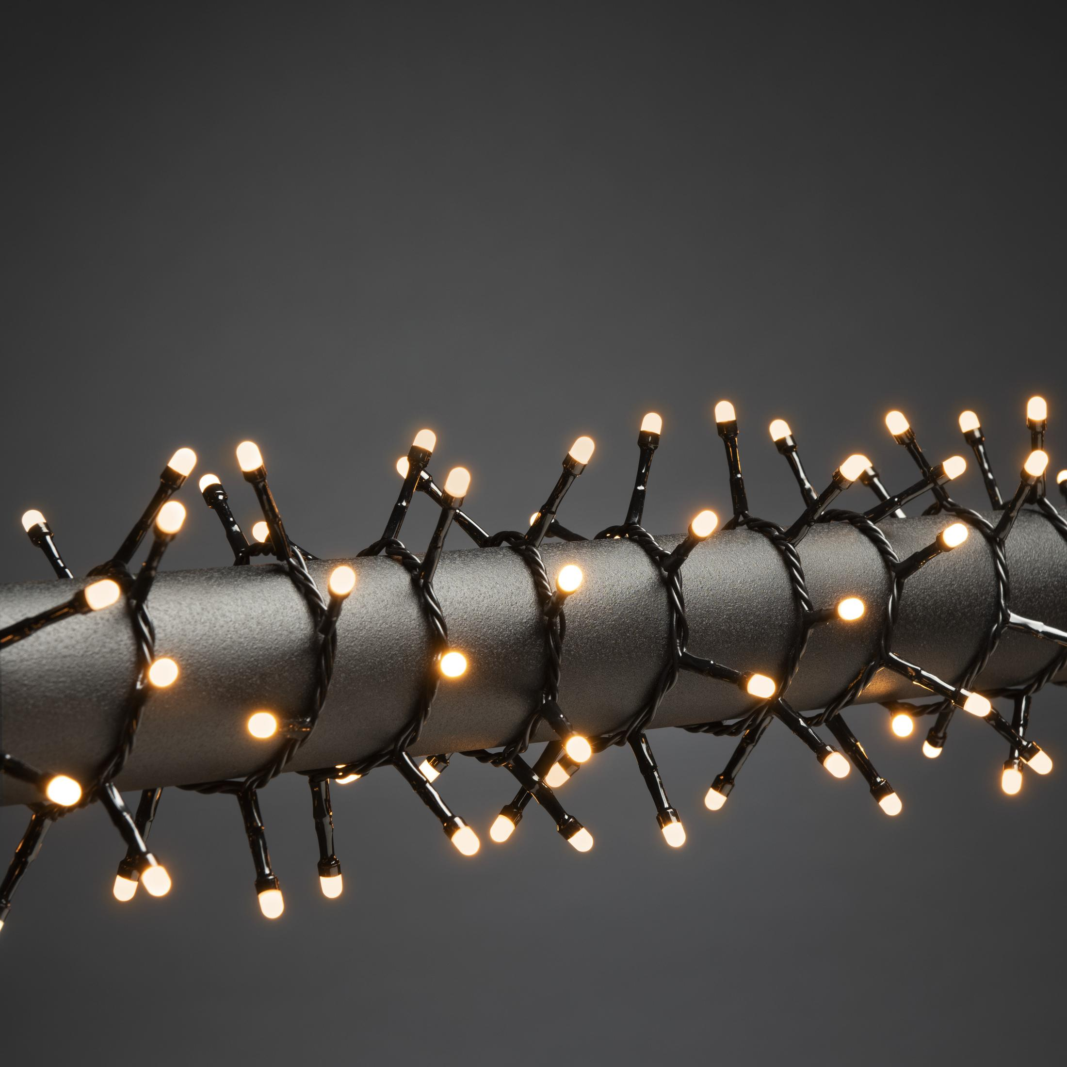 Lichterkette an einer dunklen Stange. Die Lichter sind klein und gelb, mit dunklem Hintergrund.