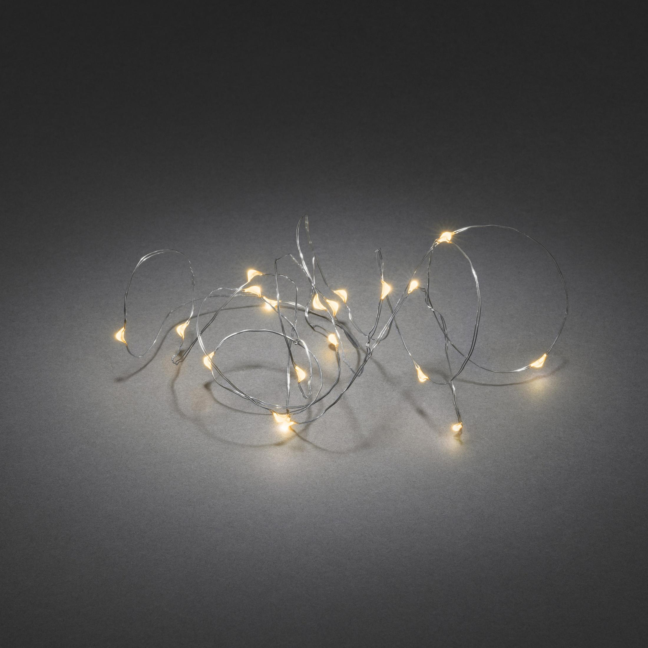Lichterkette auf grauem Untergrund, kleine gelbe Lichter auf silbernem Draht.