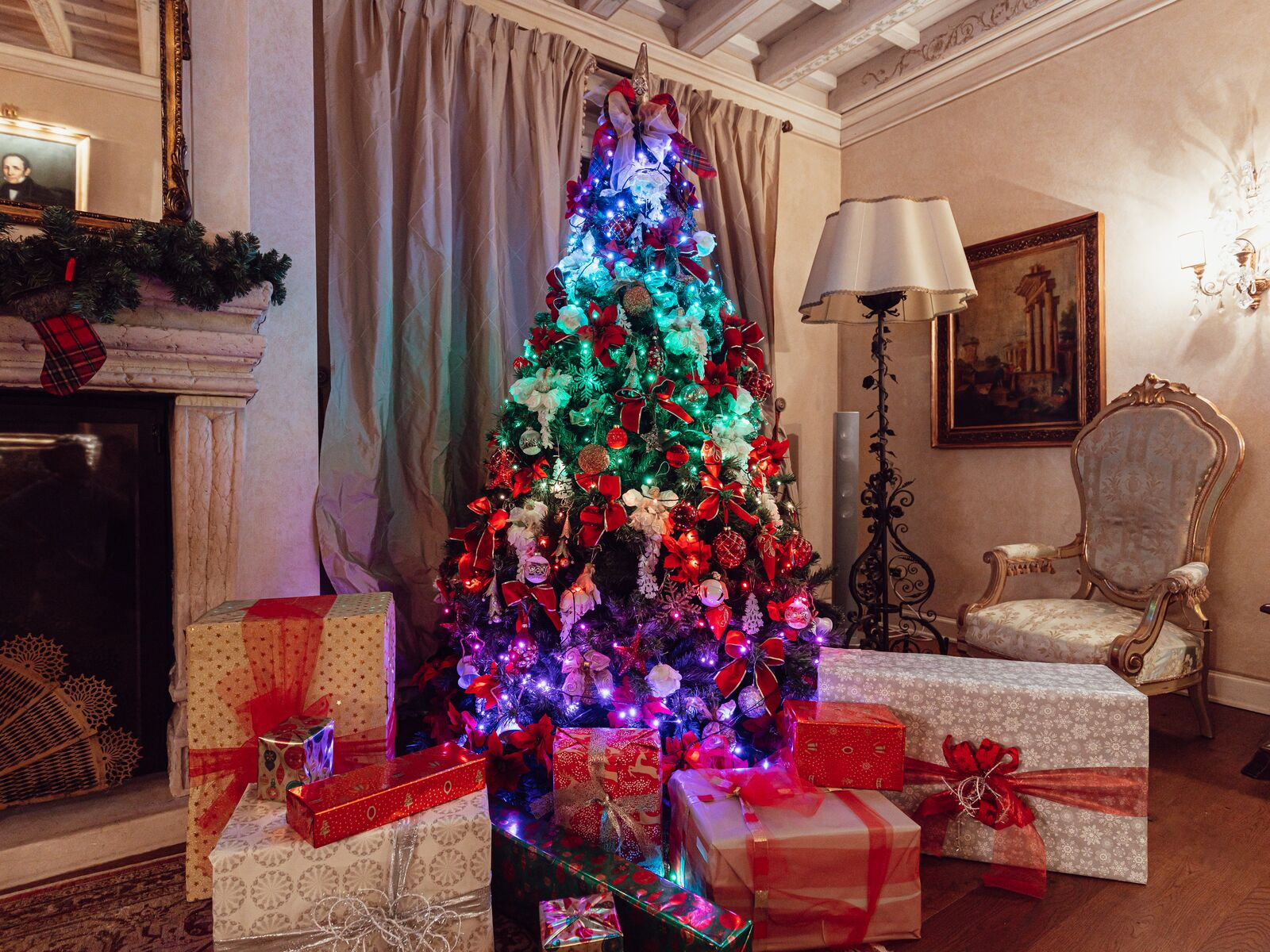 Udekorowana choinka. Prezenty pod choinką i kominek po lewej stronie. Ozdobny pokój.