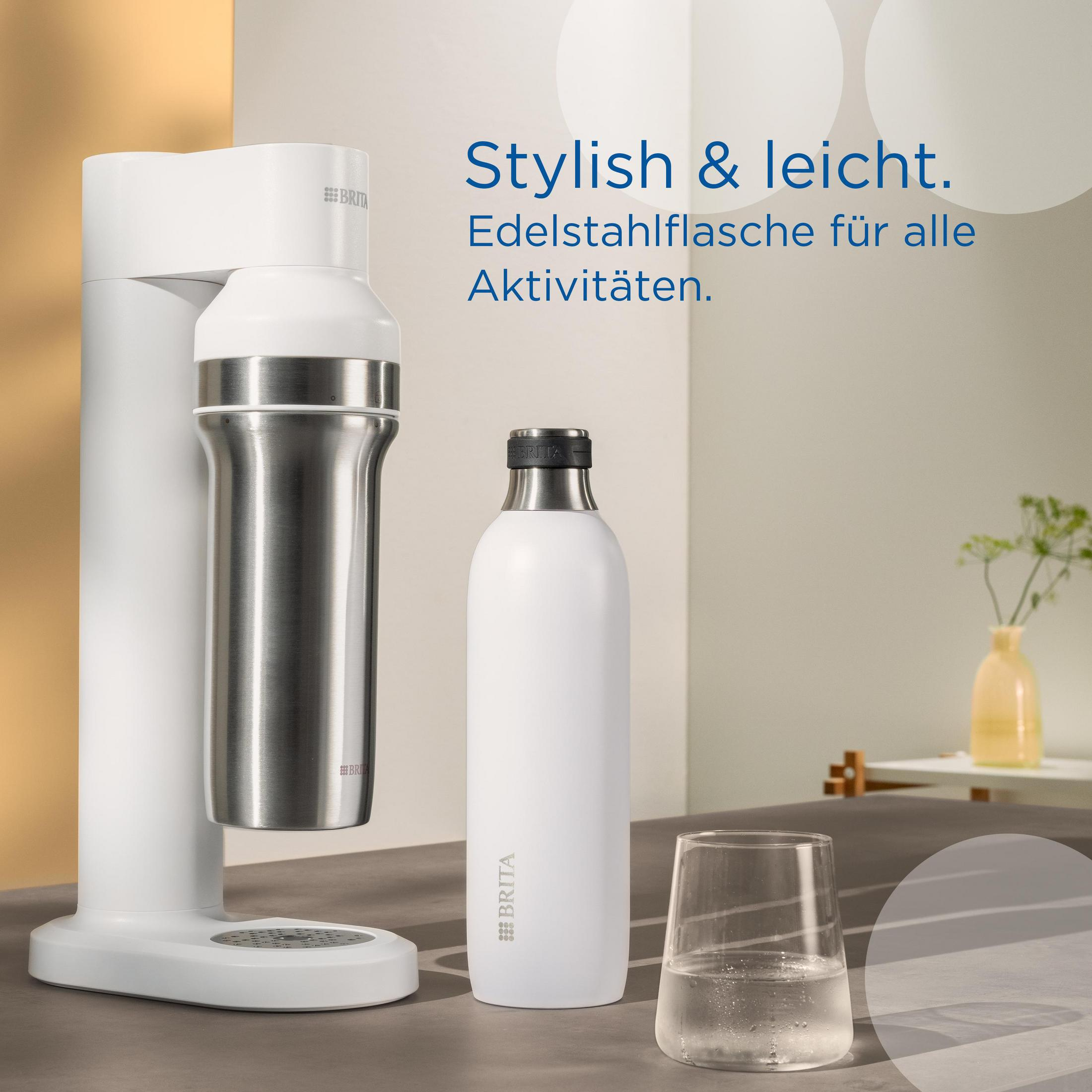 Ein weißer Wasserspender und eine Edelstahlflasche mit einem Glas Wasser auf einer Theke.