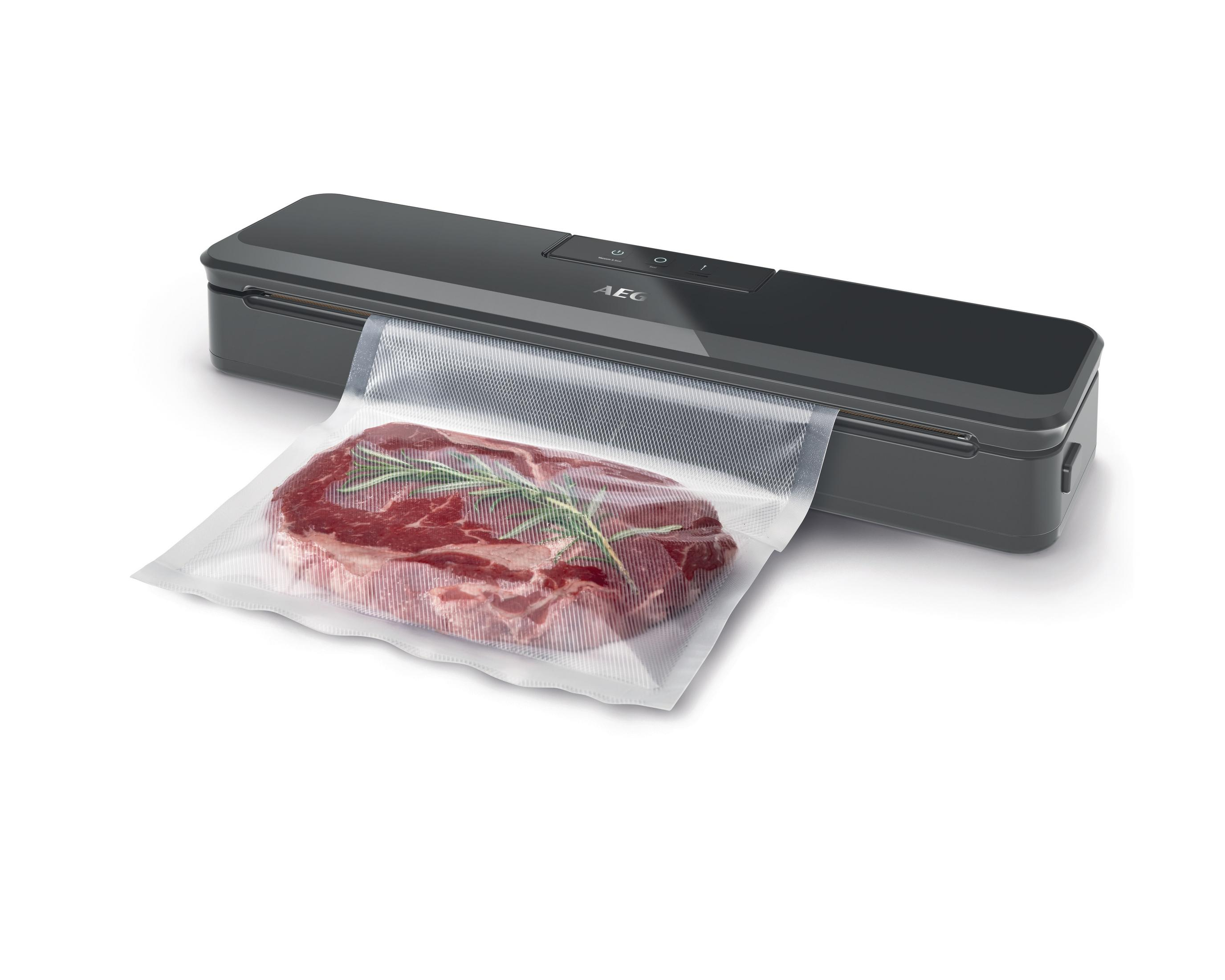 Vakuumierer und ein Steak in einem Plastikbeutel mit Rosmarin.