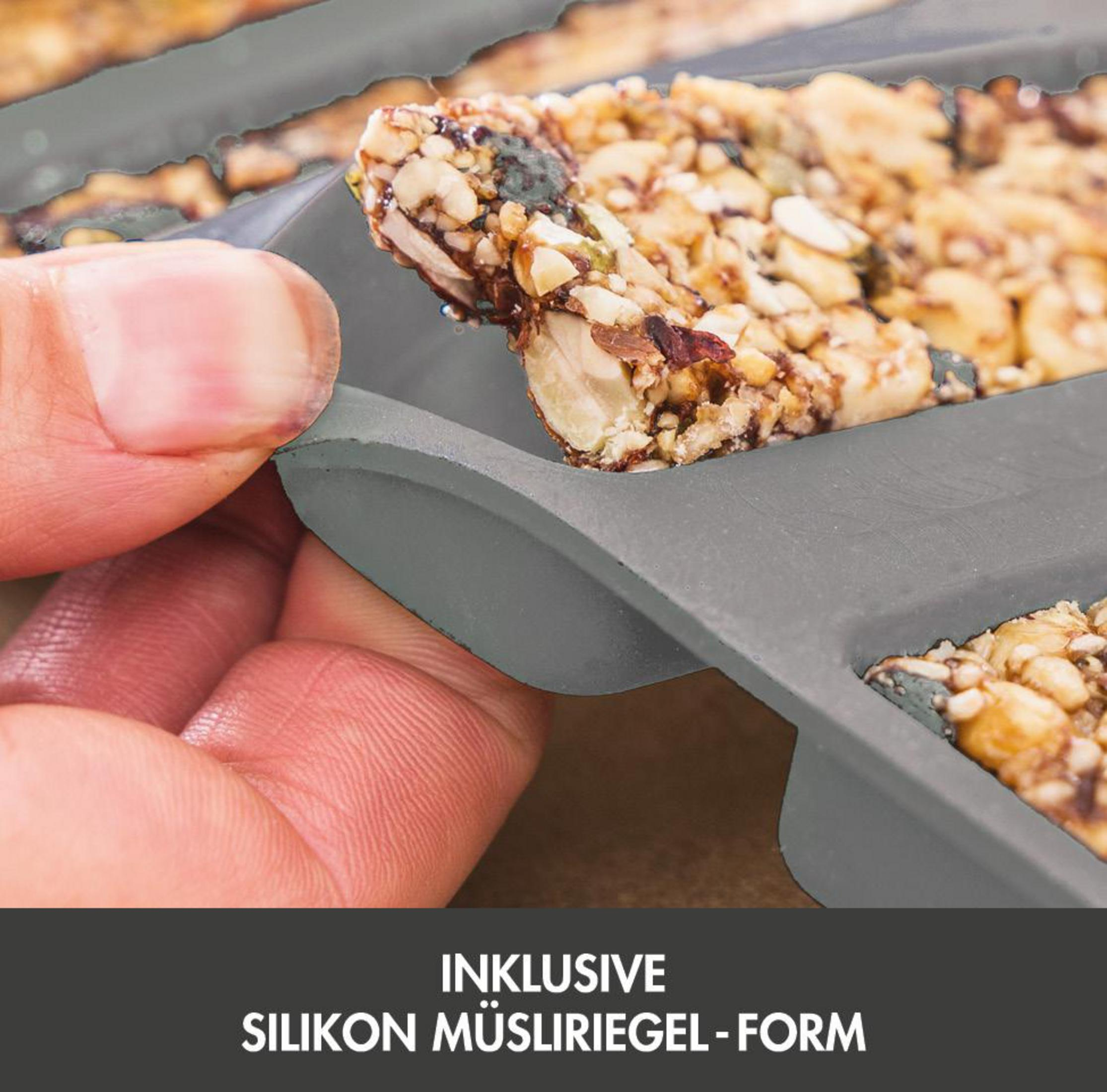 Mano tiene barretta granola in stampo silicone grigio. Testo in basso.