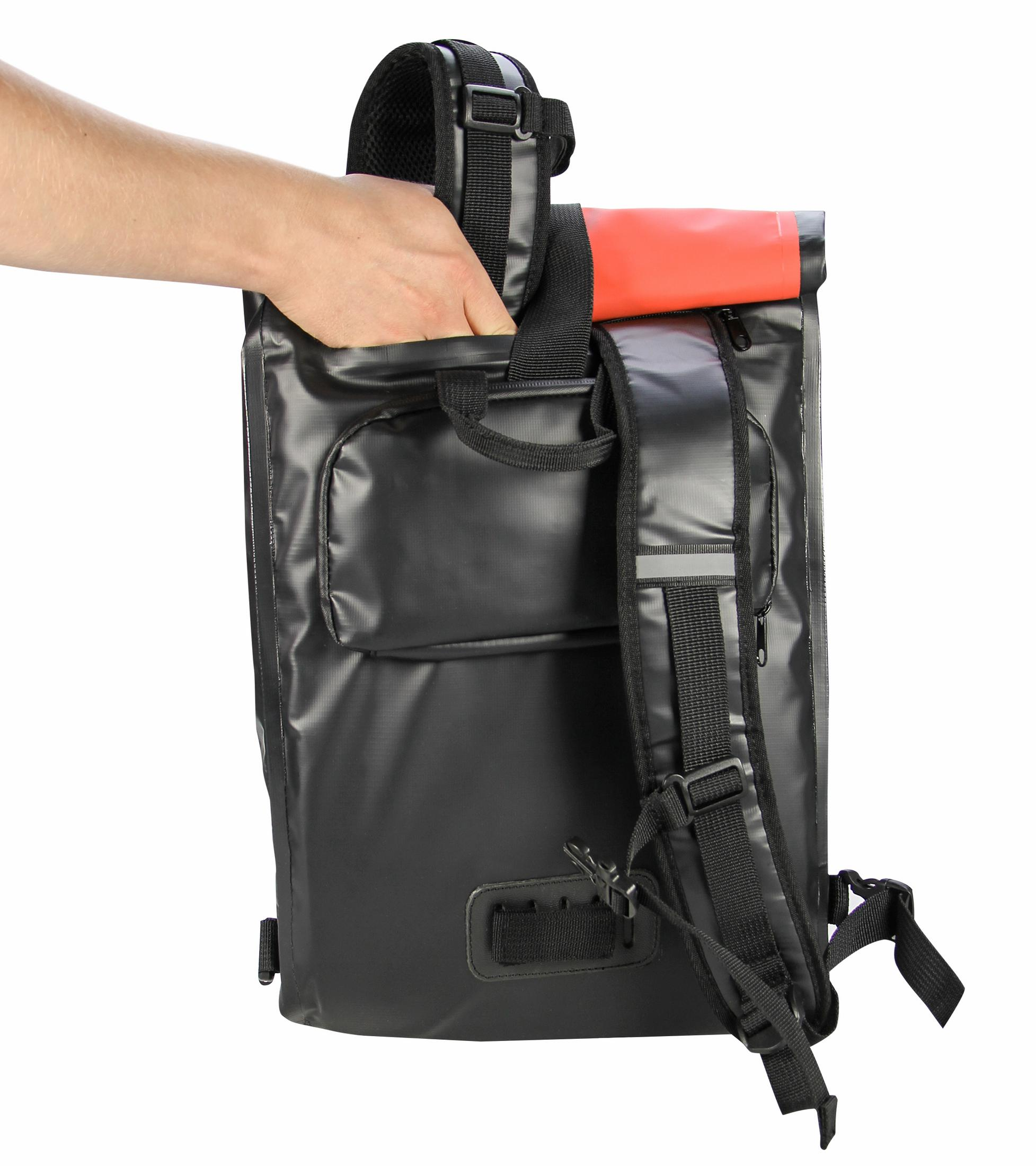 Eine Hand greift in einen schwarzen Rucksack mit roter Oberseite. Der Hintergrund ist weiß.