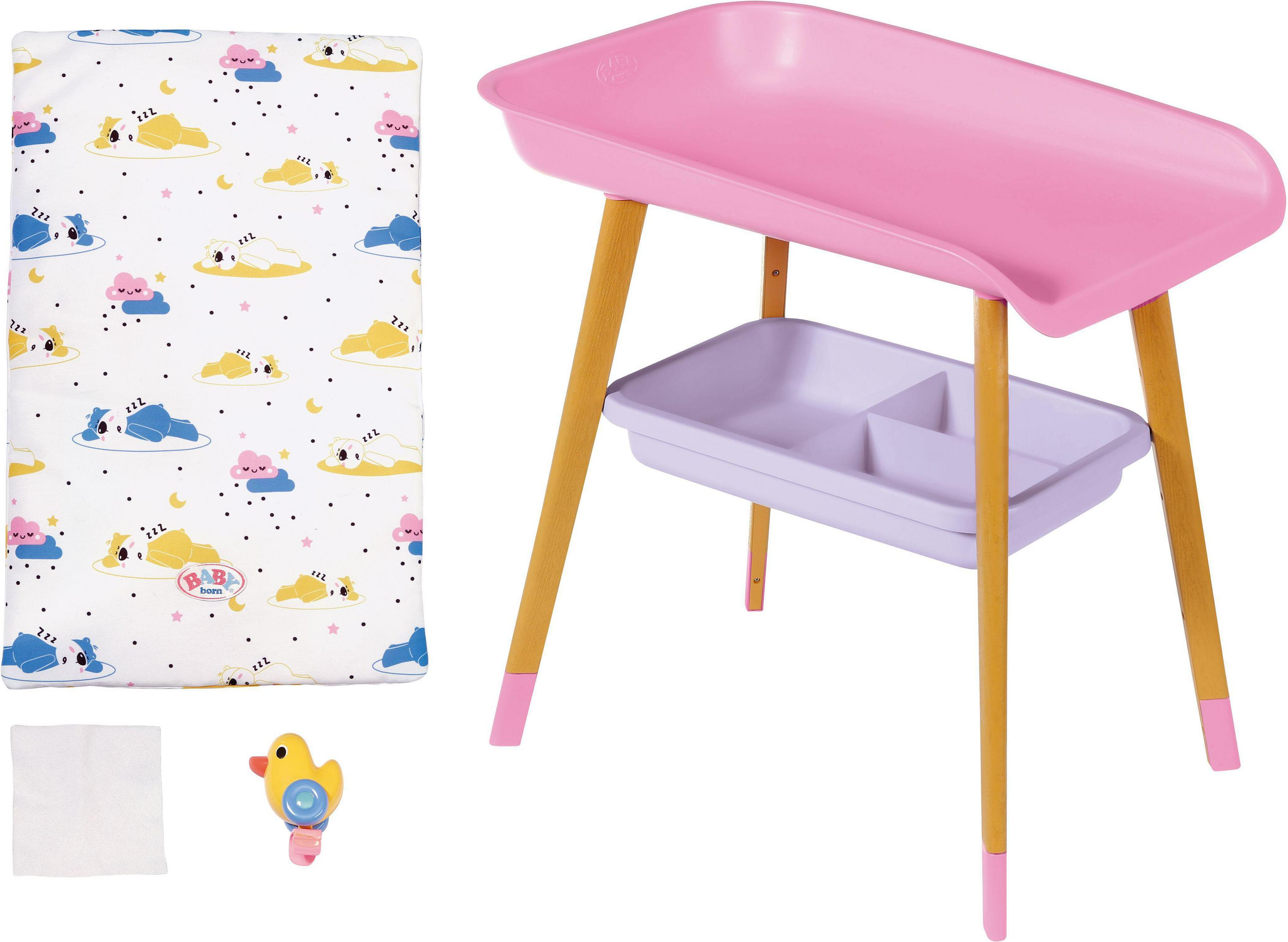 Cambiador rosa con patas de madera, cambiador y accesorios como un juguete.