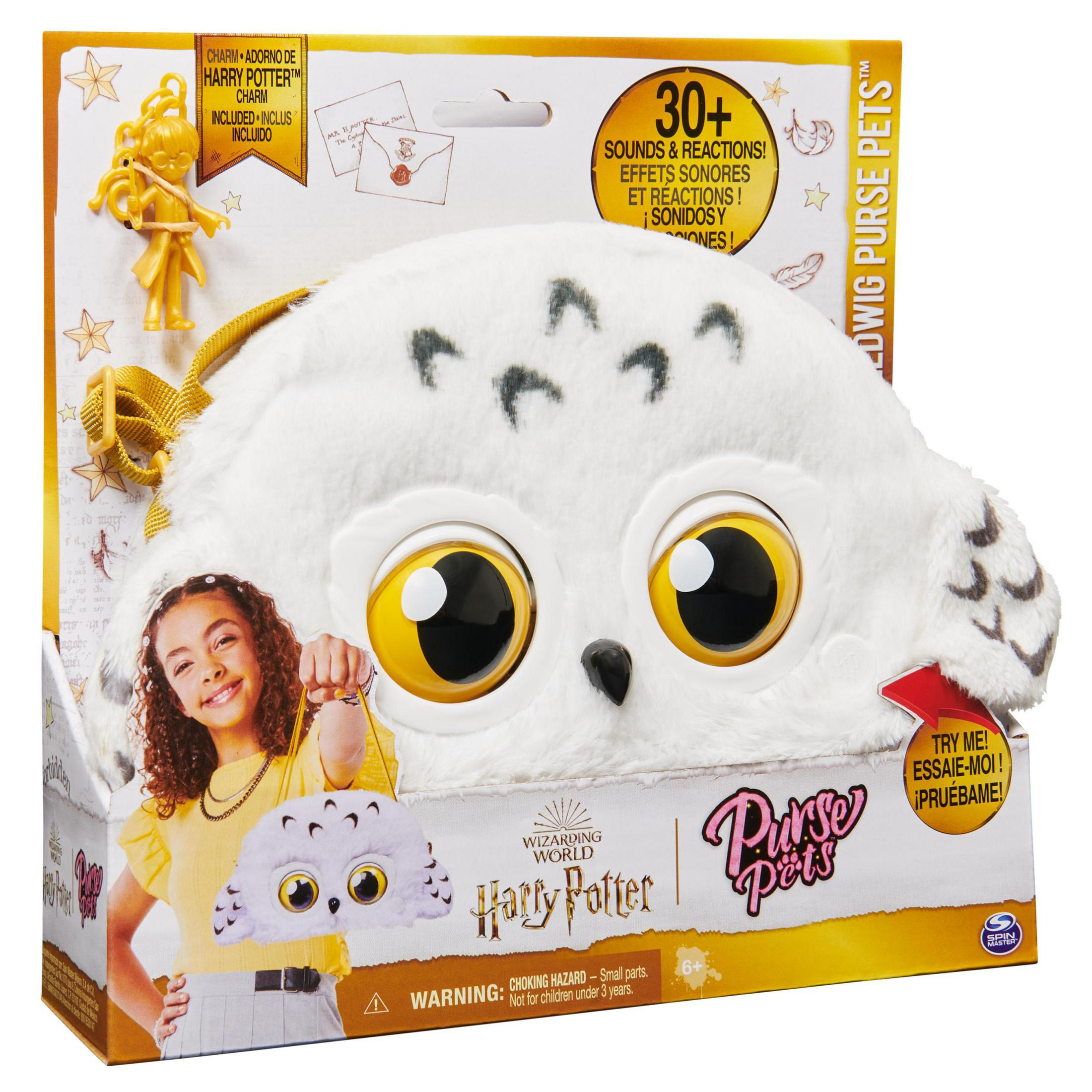 Eine Spielzeug-Geldbörse in Form einer Eule, mit einem Mädchen, das eine kleinere Version hält. Die Schachtel zeigt das Produkt.