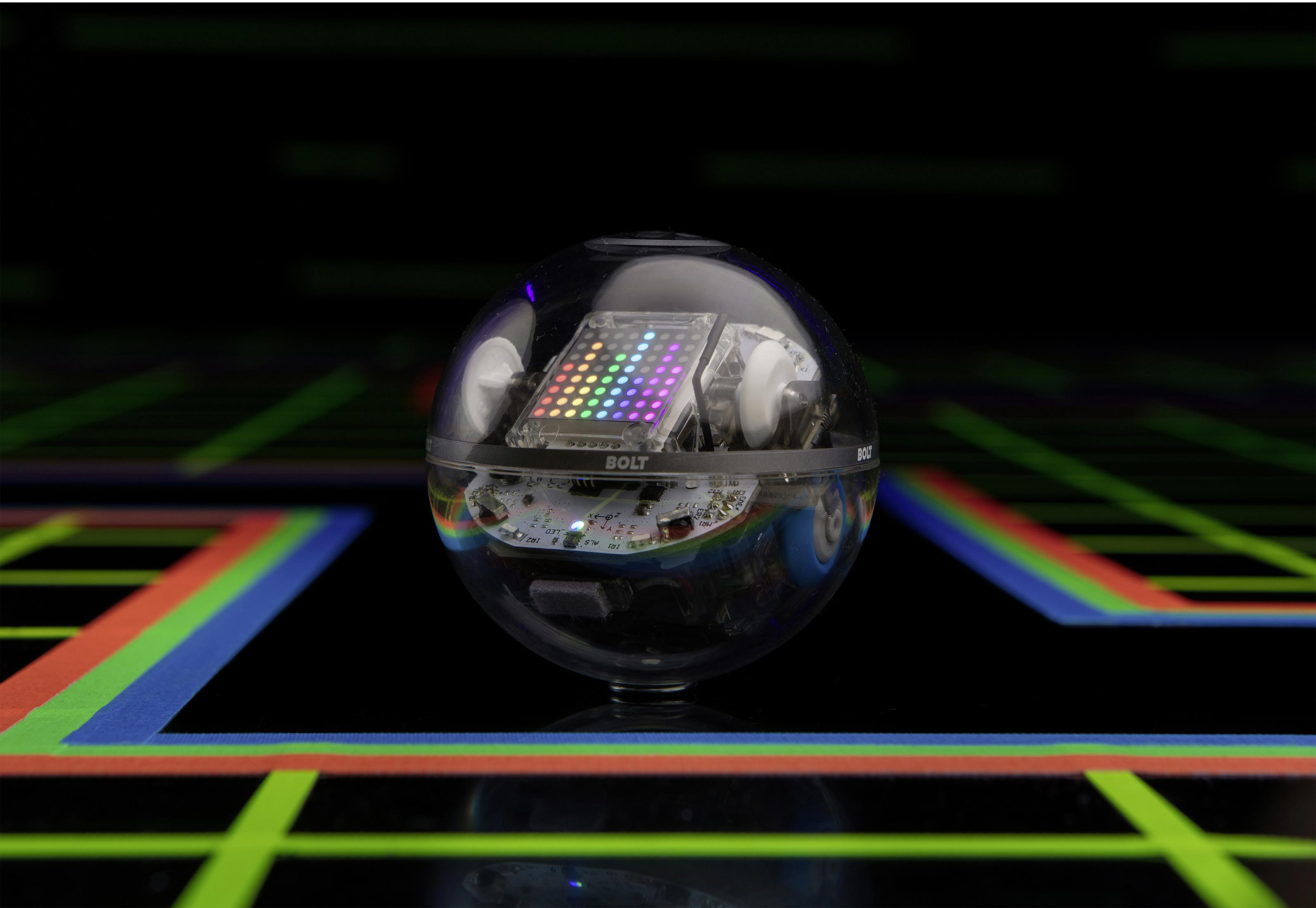 Una sfera robotica Sphero BOLT con uno sfondo a griglia, che mostra una matrice LED colorata.