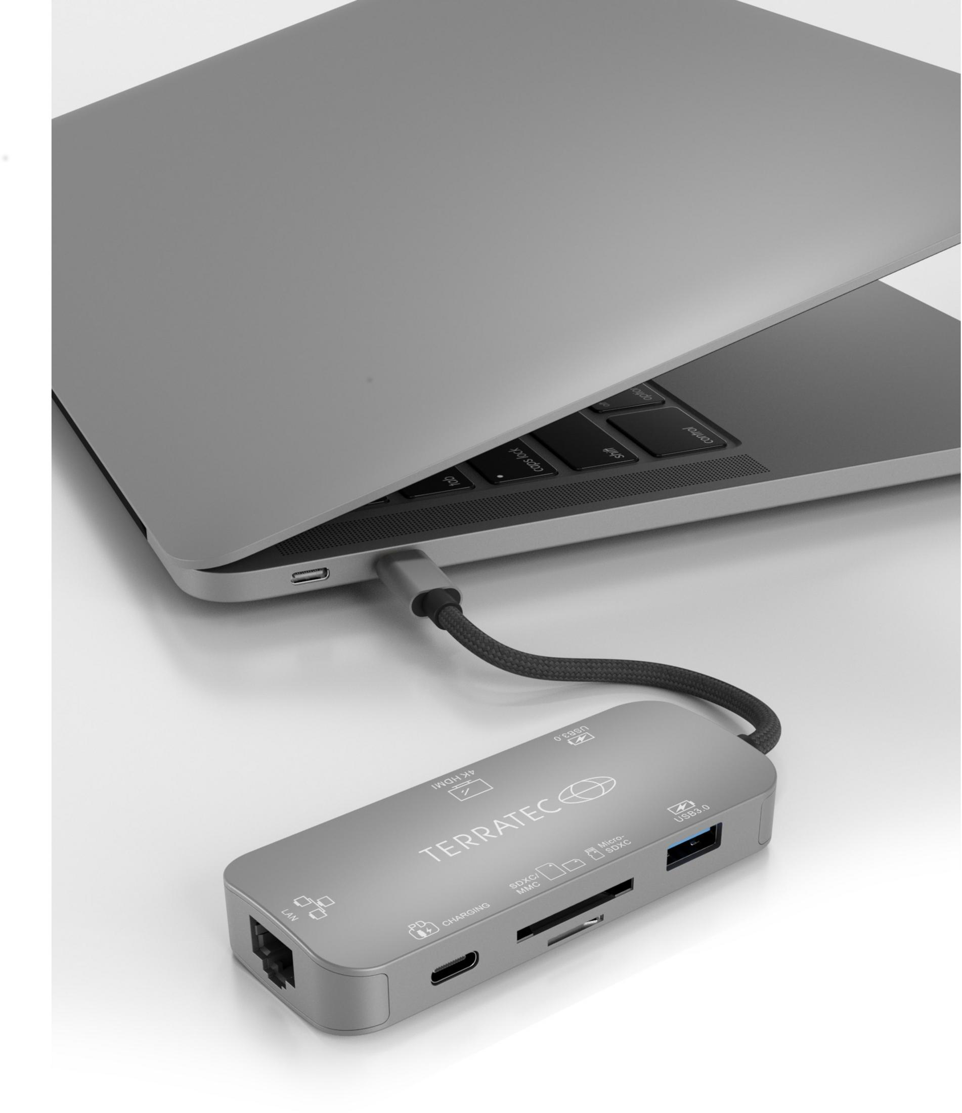 Ein Laptop, der mit einem Hub mit mehreren Anschlüssen verbunden ist. Der Hub ist silber.