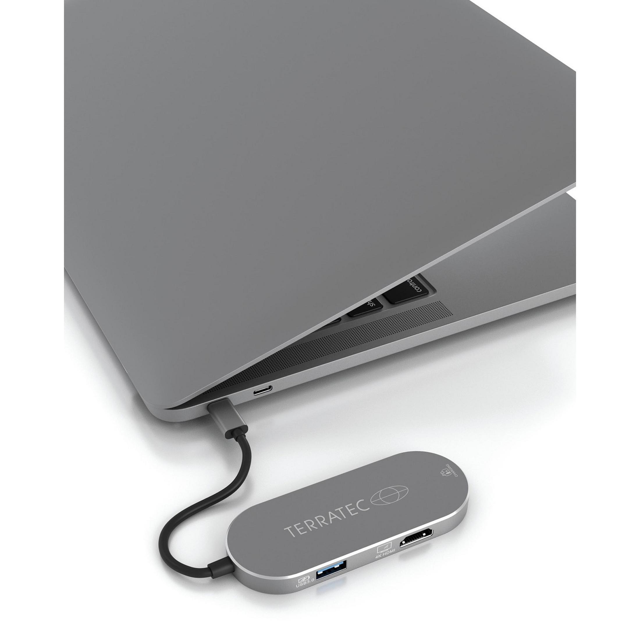 Laptop mit angeschlossenem silbernen Hub. Der Hub zeigt Anschlüsse wie USB und HDMI.