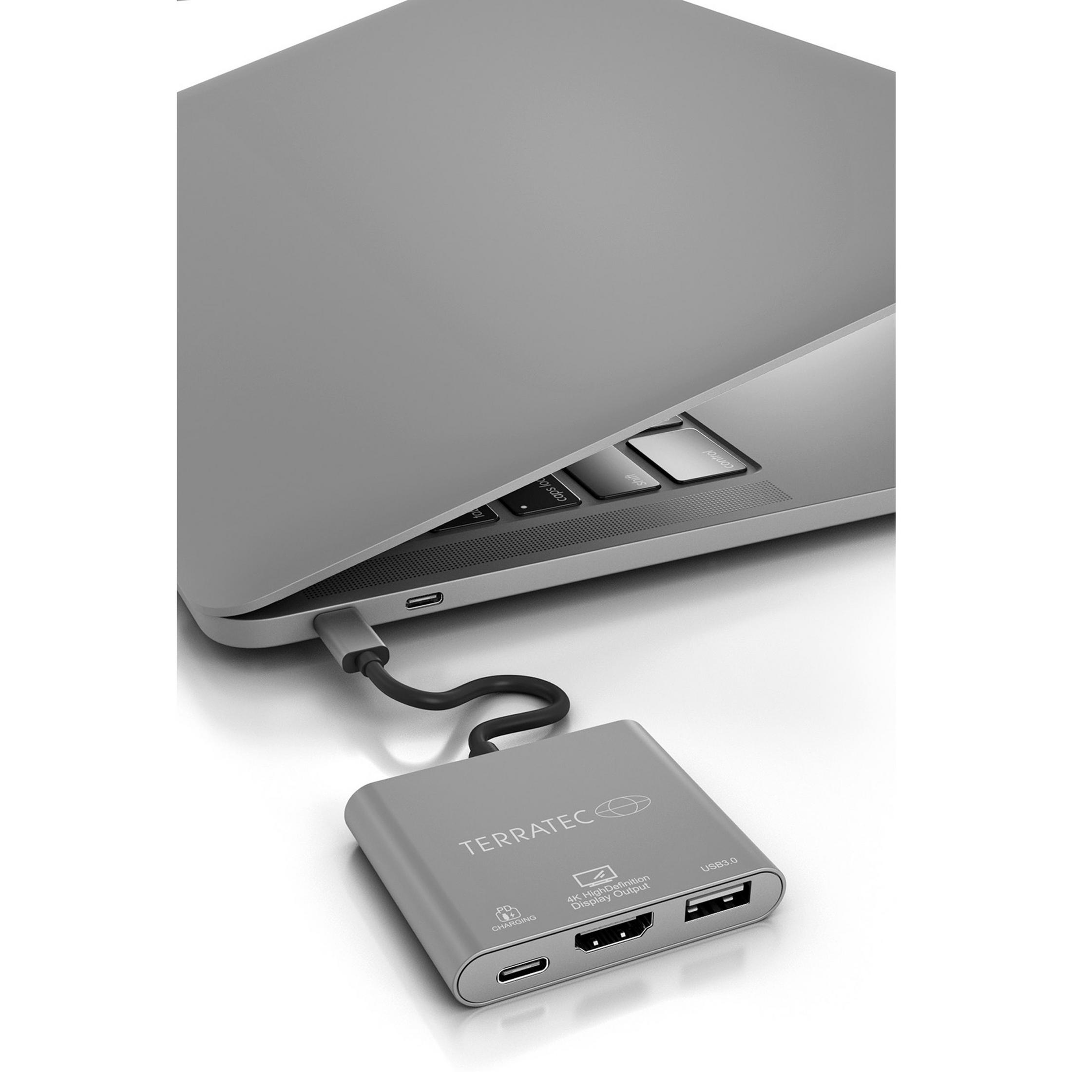 Ein Laptop ist mit einem silbernen Adapter verbunden. Der Adapter ist mit einem Kabel mit dem Laptop verbunden.