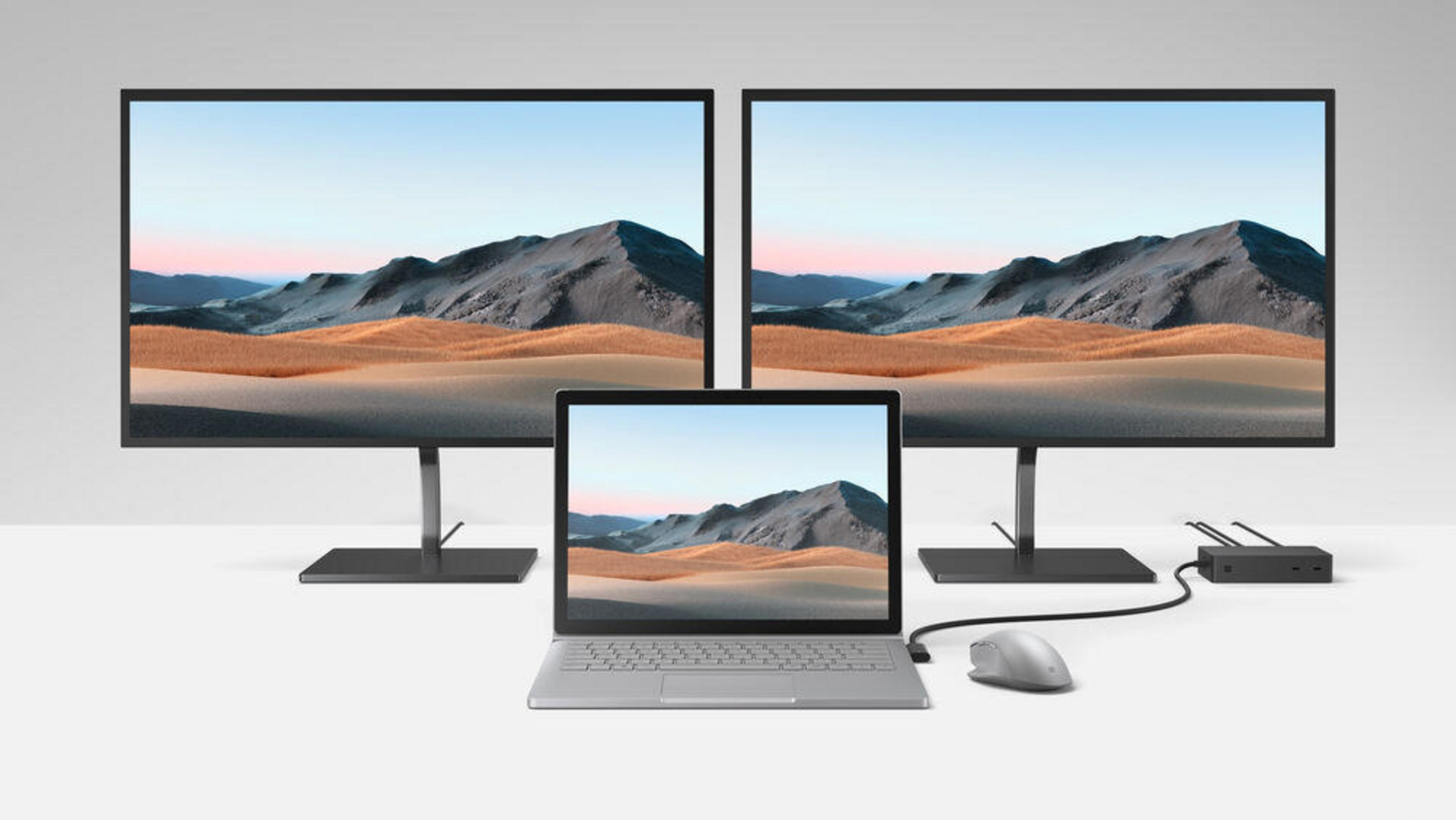 Drei Monitore, ein Laptop und eine Maus. Wüstenlandschaft. Auf weißer Oberfläche.